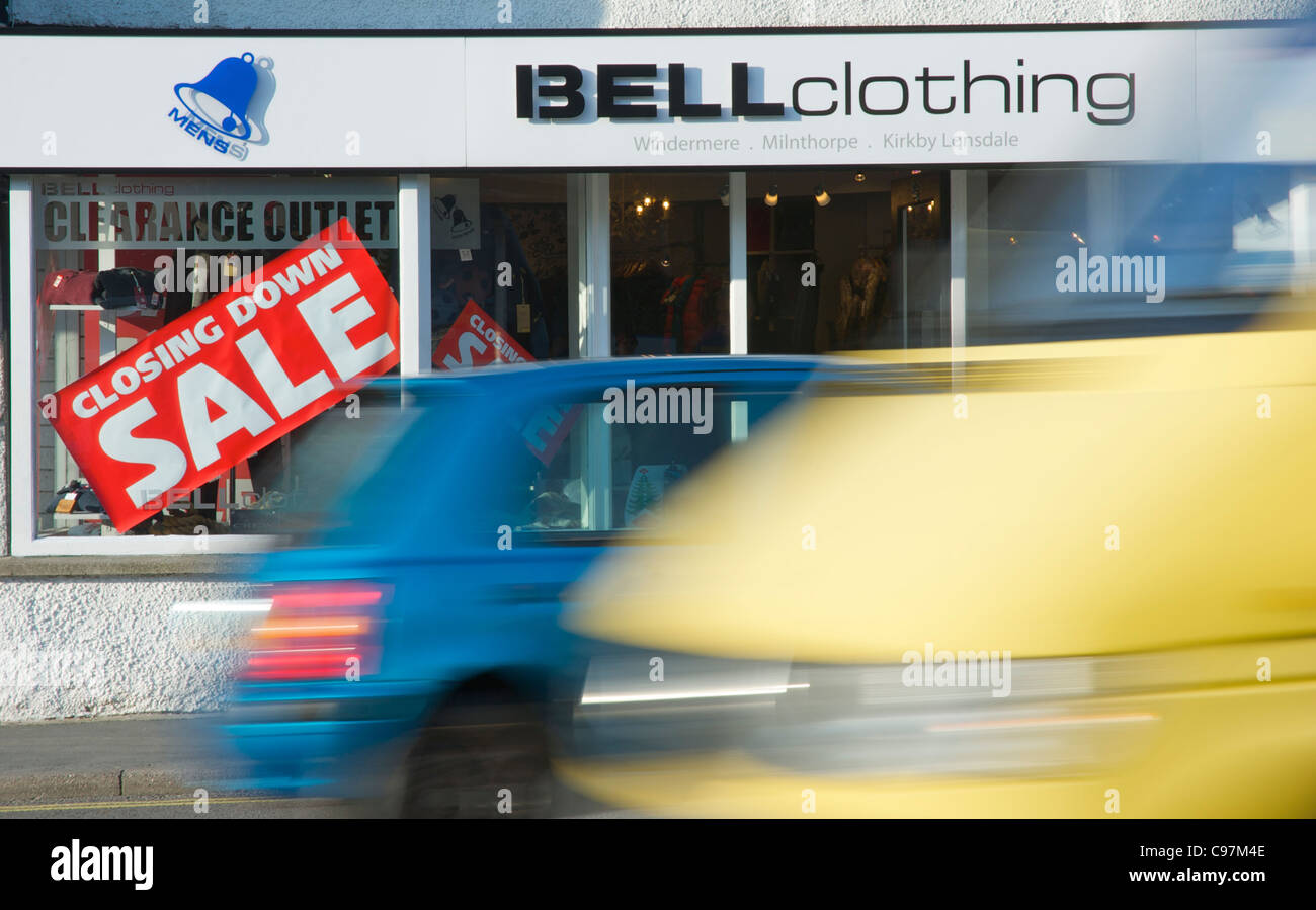 Car and van passing shop with closing down sale, Windermere town, Lake