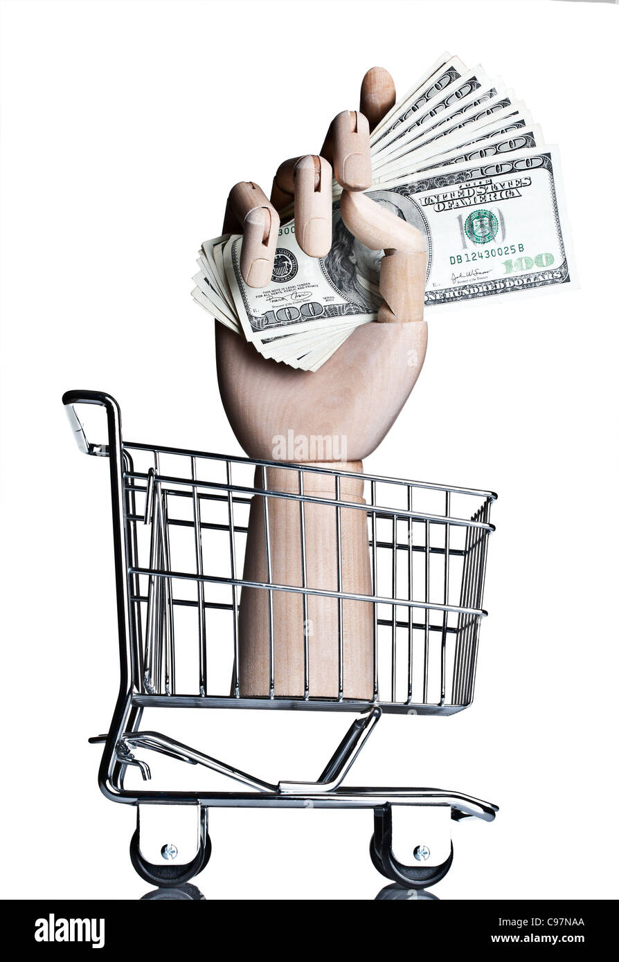 Manikin hand holding money in a miniature shopping cart Stock Photo