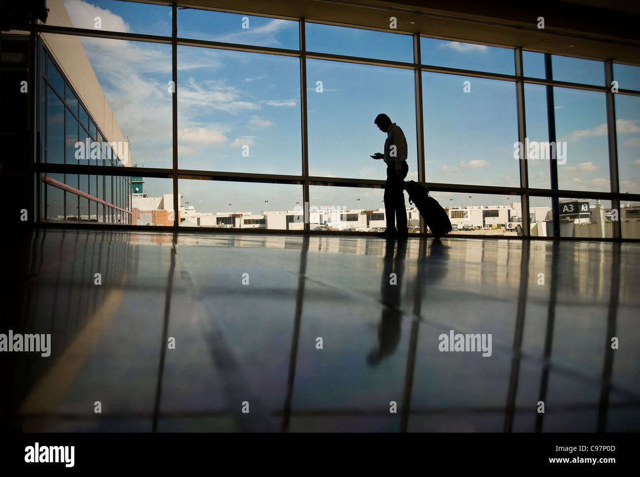Traveling Business Man Checking Email On Mobile Cell Phone In Airport, Philadelphia USA Stock Photo