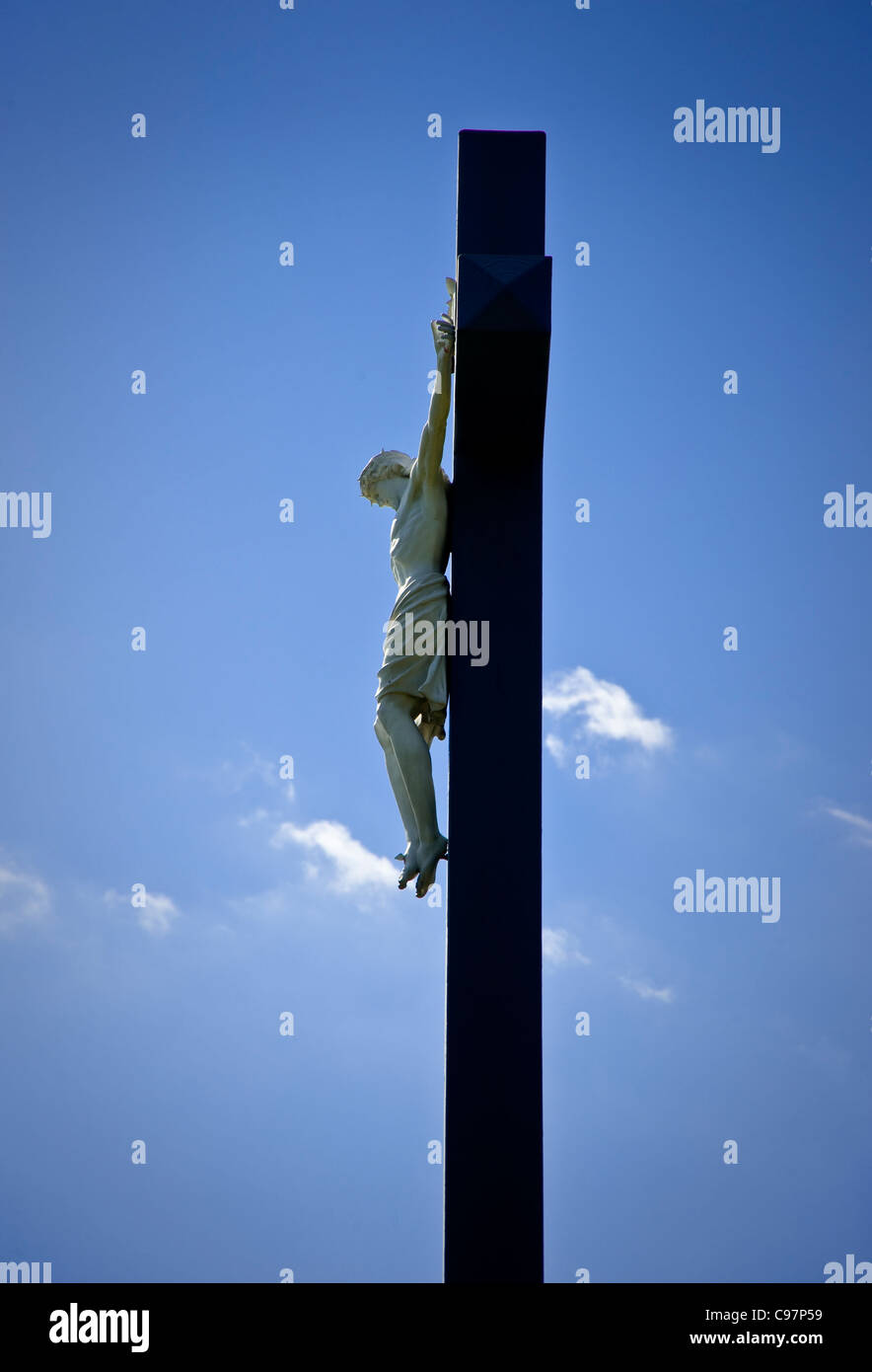 Jesus Christ Hanging On Outdoor Cross With Blue Sky & Clouds Stock Photo