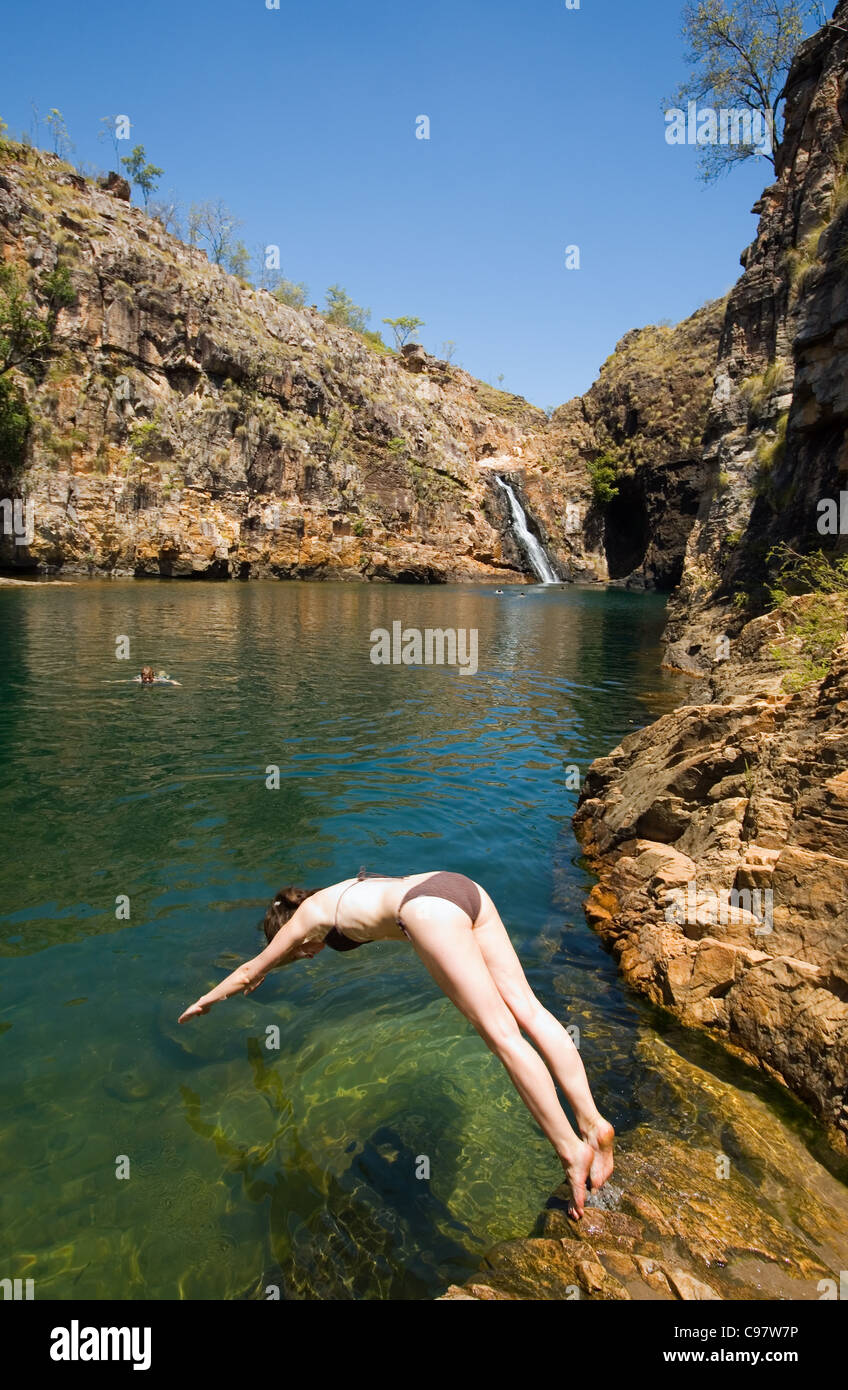A woman dives into the clear waters of Maguk (Barramundi Gorge) - a popular swimming hole in Kakadu National Park, Northern Terr Stock Photo