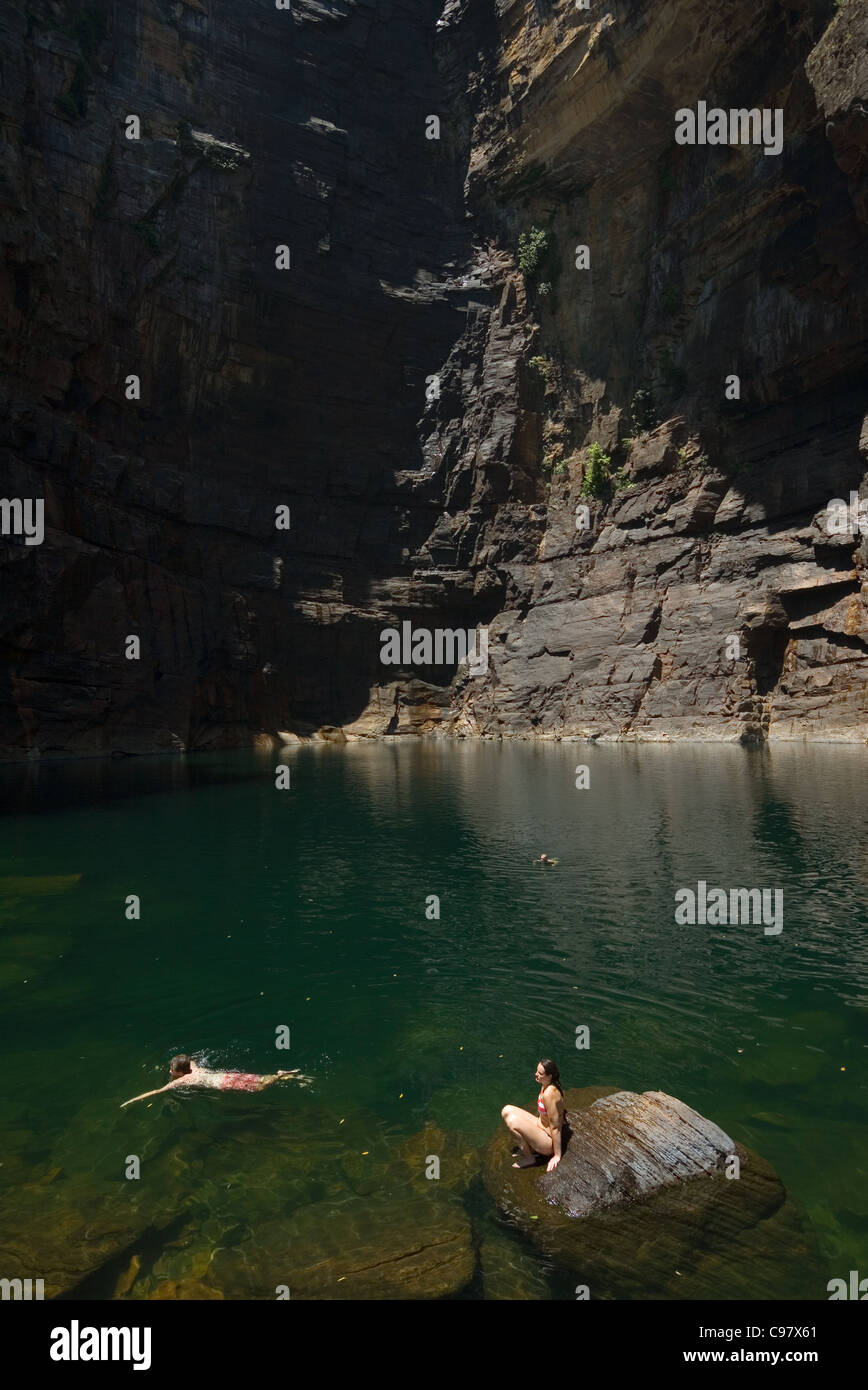 Tourists swim in the Jim Jim Falls plunge pool, surrounded by escarpment walls. Kakadu National Park, Northern Territory, Austra Stock Photo