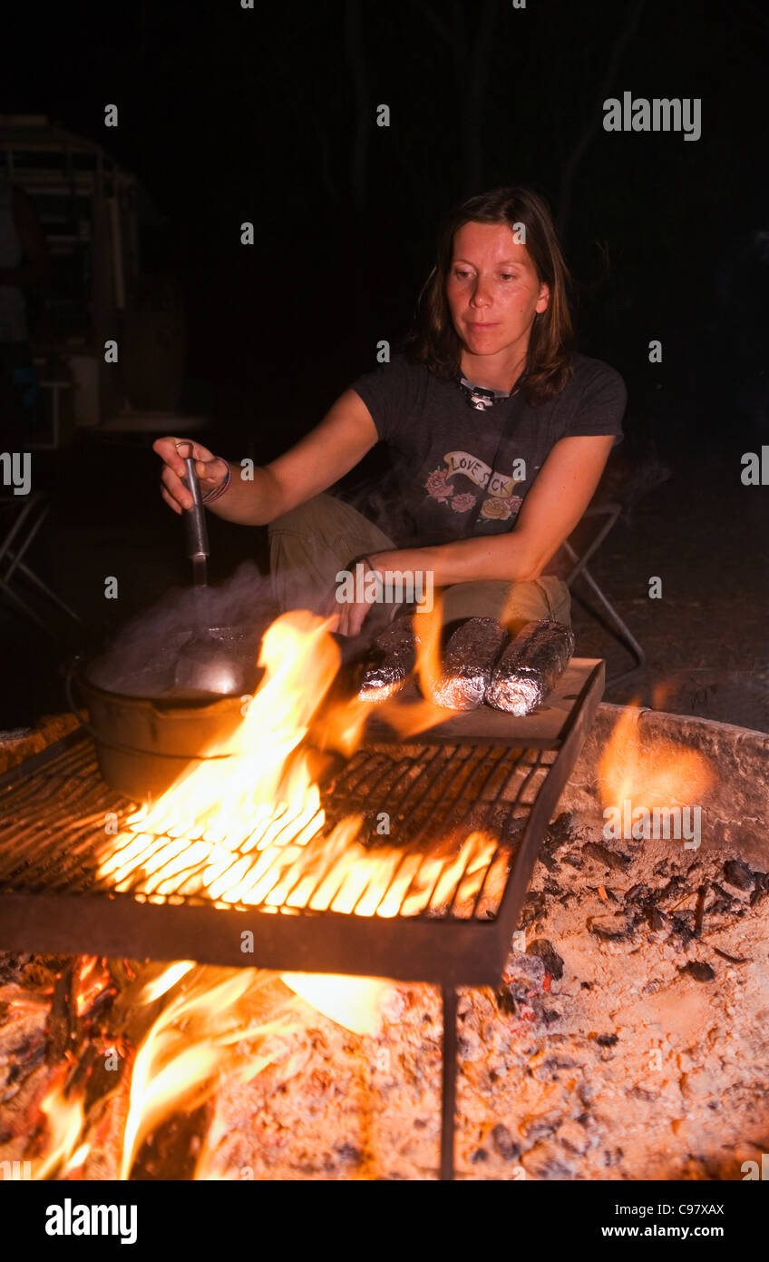 Woman cooking on a campfire in Kakadu National Park, Northern Territory, Australia Stock Photo