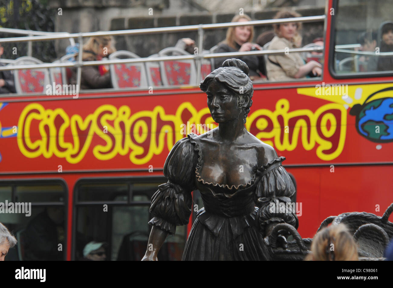 PASSENGERS ON A DUBLIN SIGHTSEEING BUS PEER OUT AT THE STATUE OF MOLLY MALONE. Stock Photo