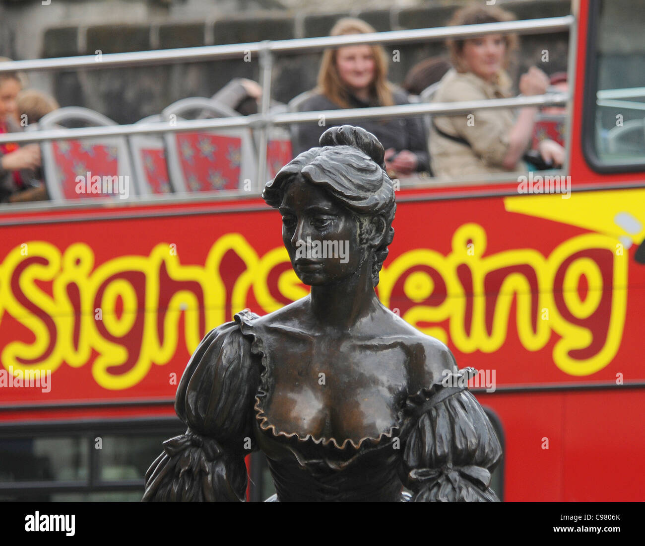 PASSENGERS ON A DUBLIN SIGHTSEEING BUS PEER OUT AT THE STATUE OF MOLLY MALONE. Stock Photo