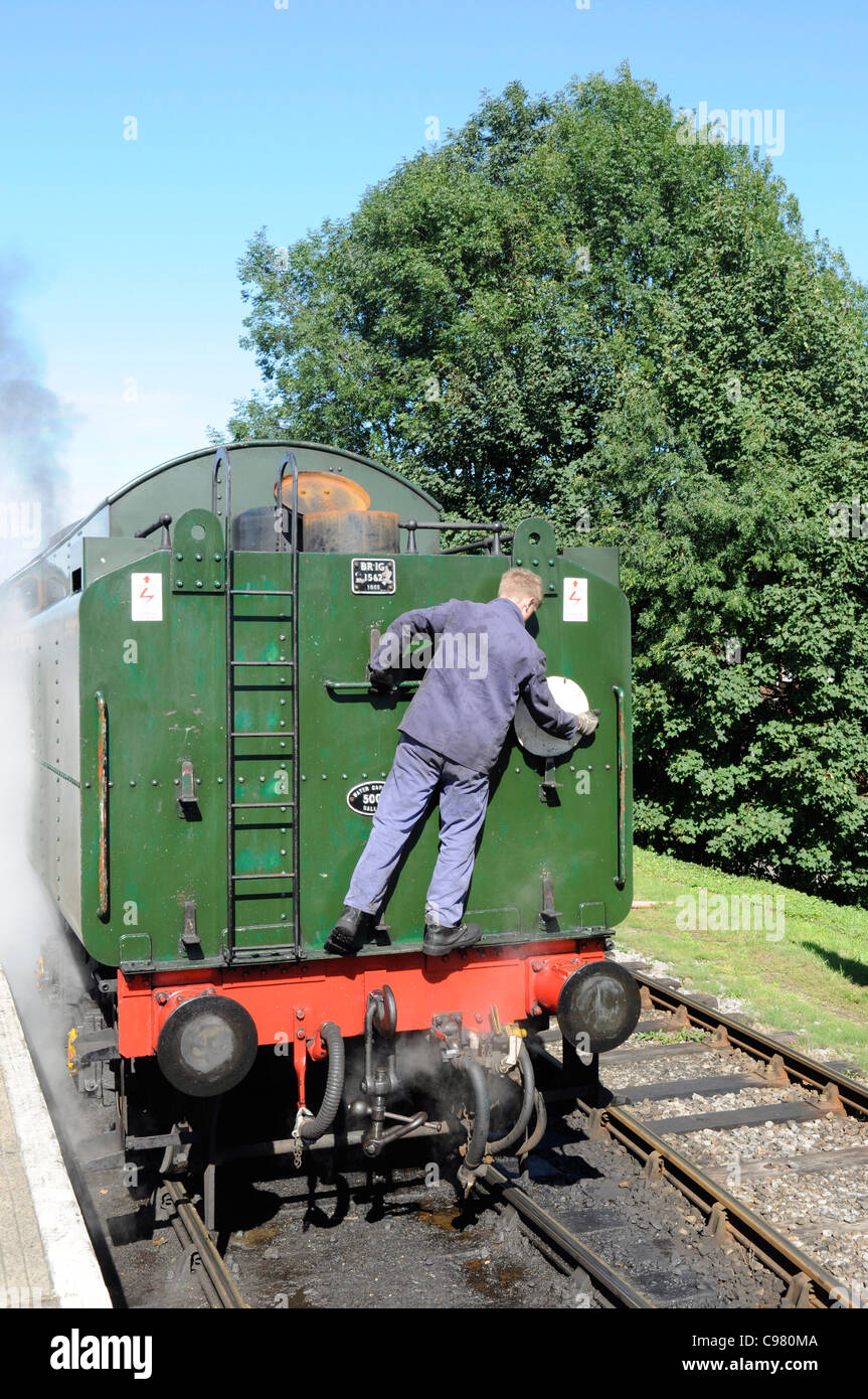 Crew member attaching the head code disk to the loco tender on the Mid Hants Railway (Watercress Line), Hampshire, England UK Stock Photo