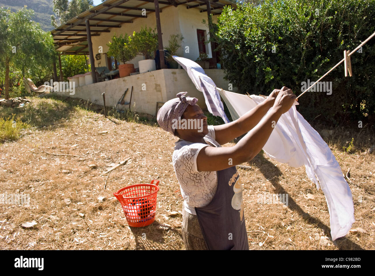 A maid hangs out the washing on a farm in Riebeeksrivier, in the Western Cape, South Africa. Stock Photo