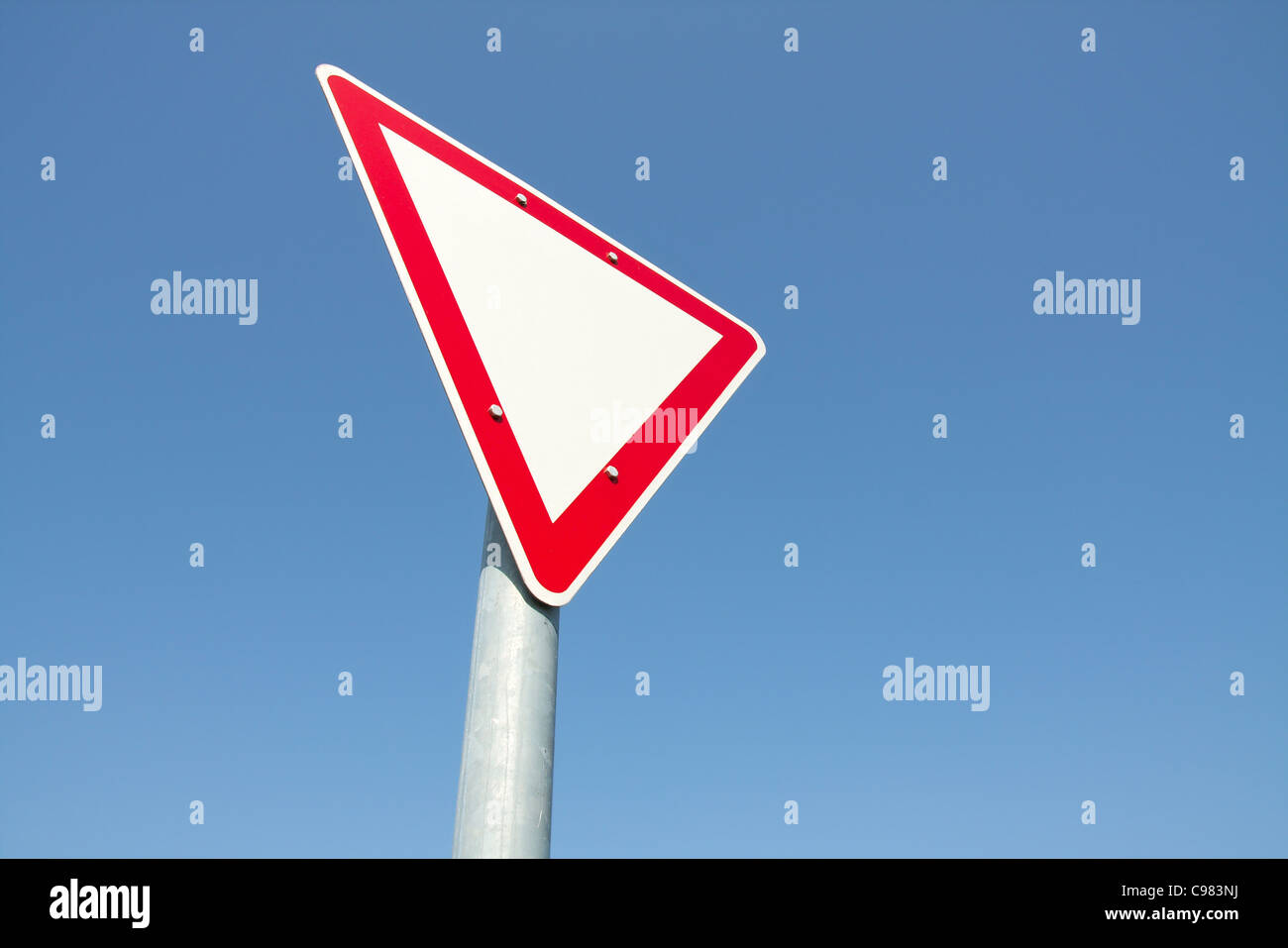 Yield traffic sign against clear blue sky Stock Photo - Alamy