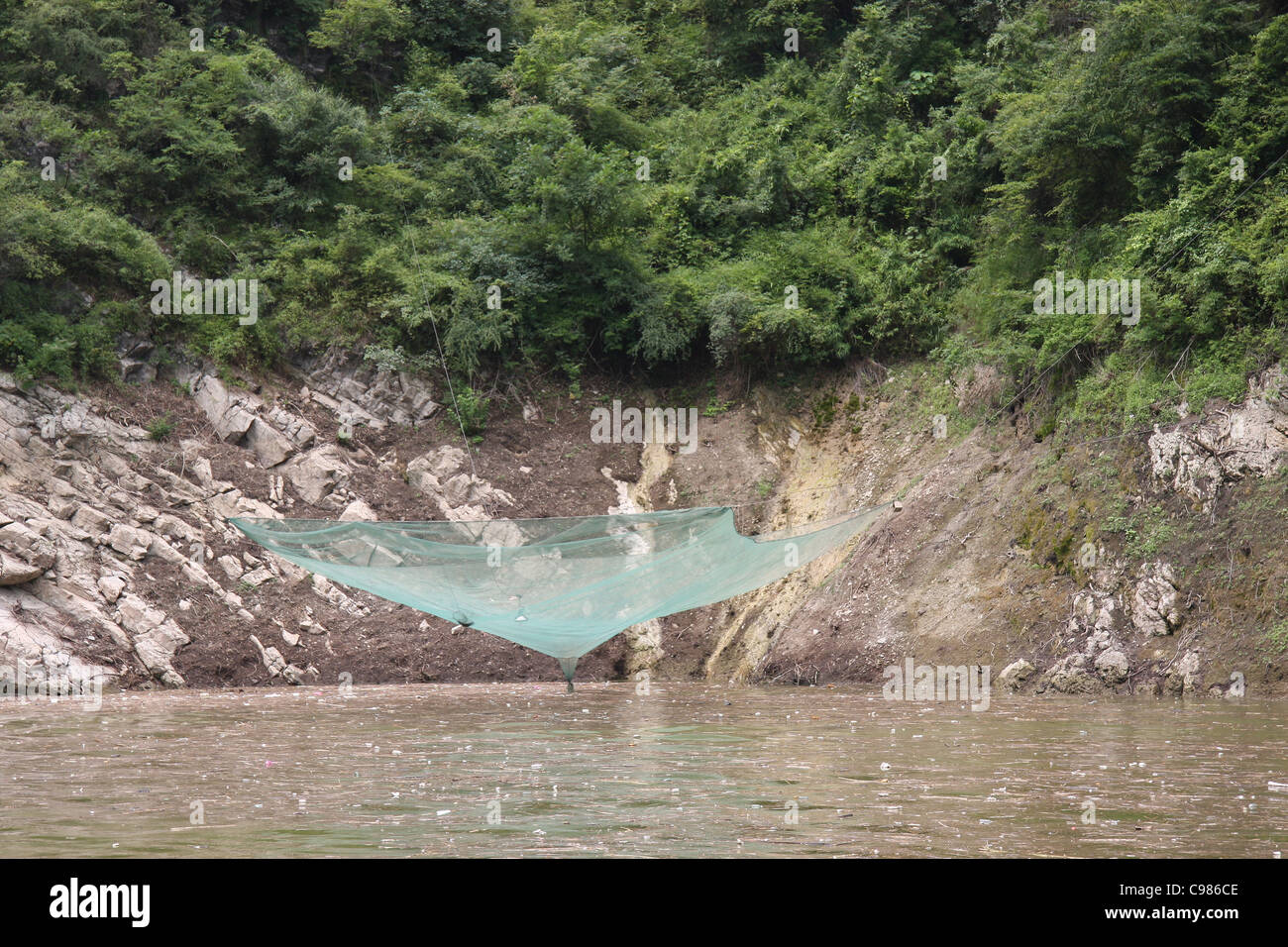 Suspended fish net over floating debris, MIsty Gorge, Lesser Three Gorges, China Stock Photo