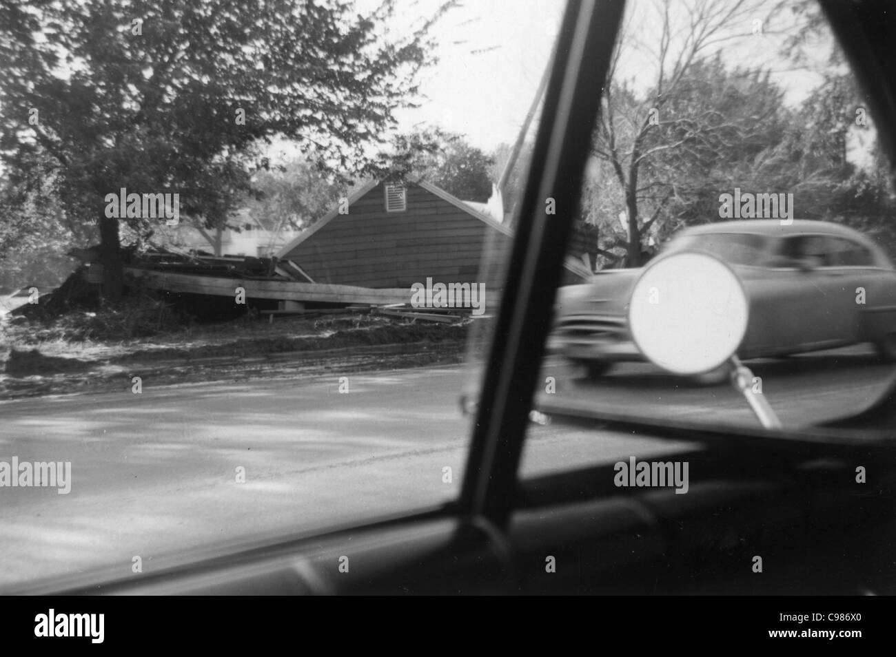 Indiana car culture 1960s black and white car passing farm house view from window driver's seat country rural Stock Photo