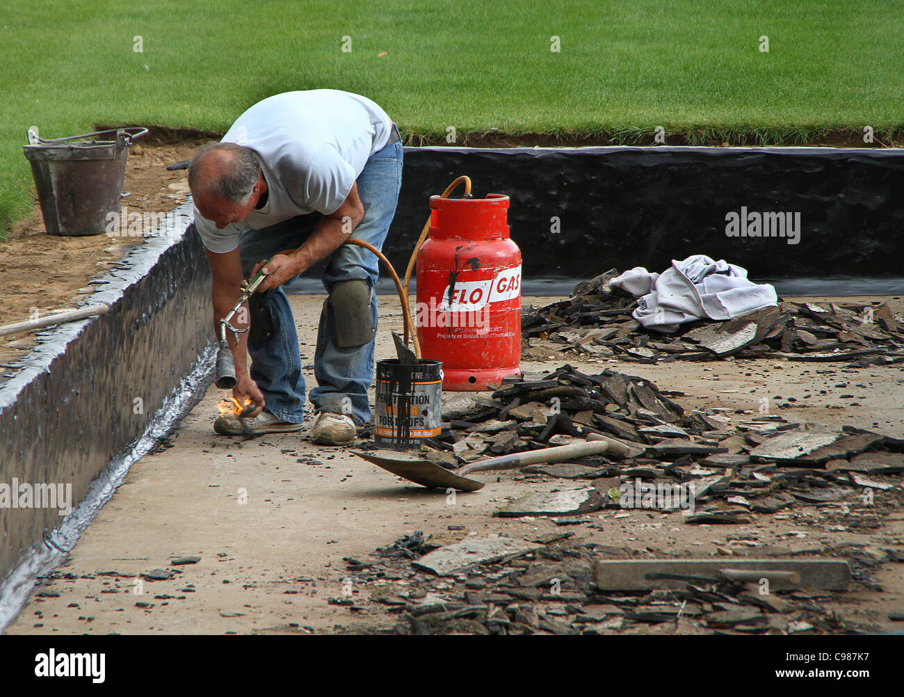 Repairing lining to large garden pond with hot pitch Stock Photo Alamy