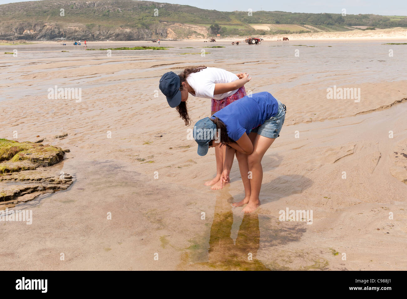 Teenagers rock pool fishing and exploring the low tide sea water