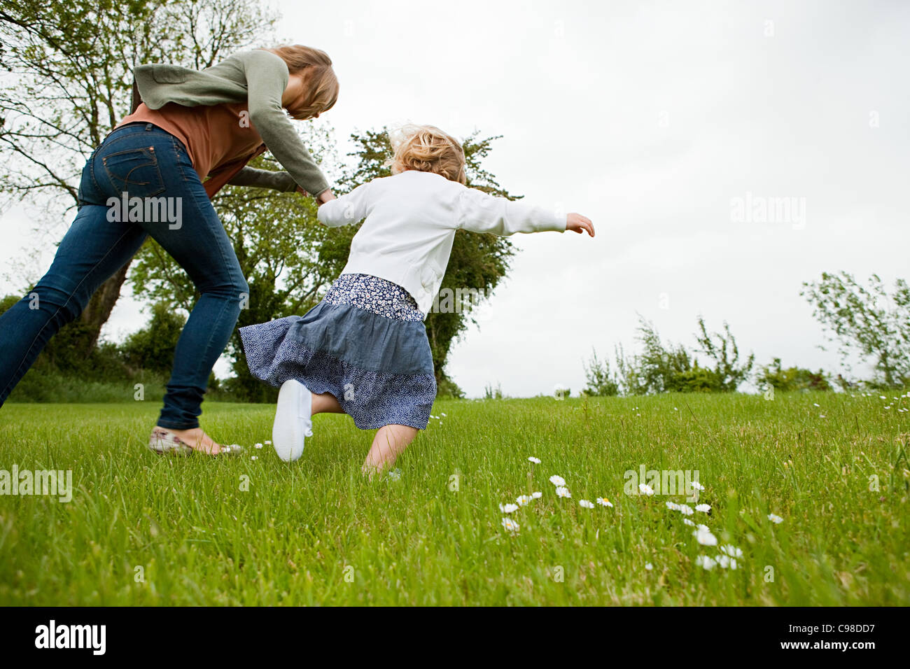 Mother and daughter running field Stock Photo