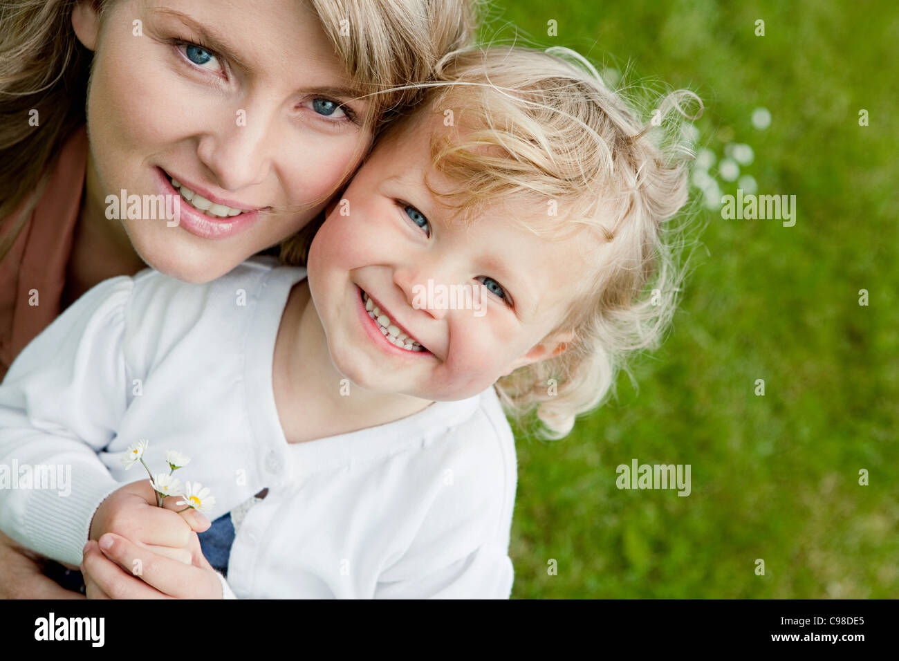 Mother and daughter holding daisies, high angle portrait Stock Photo