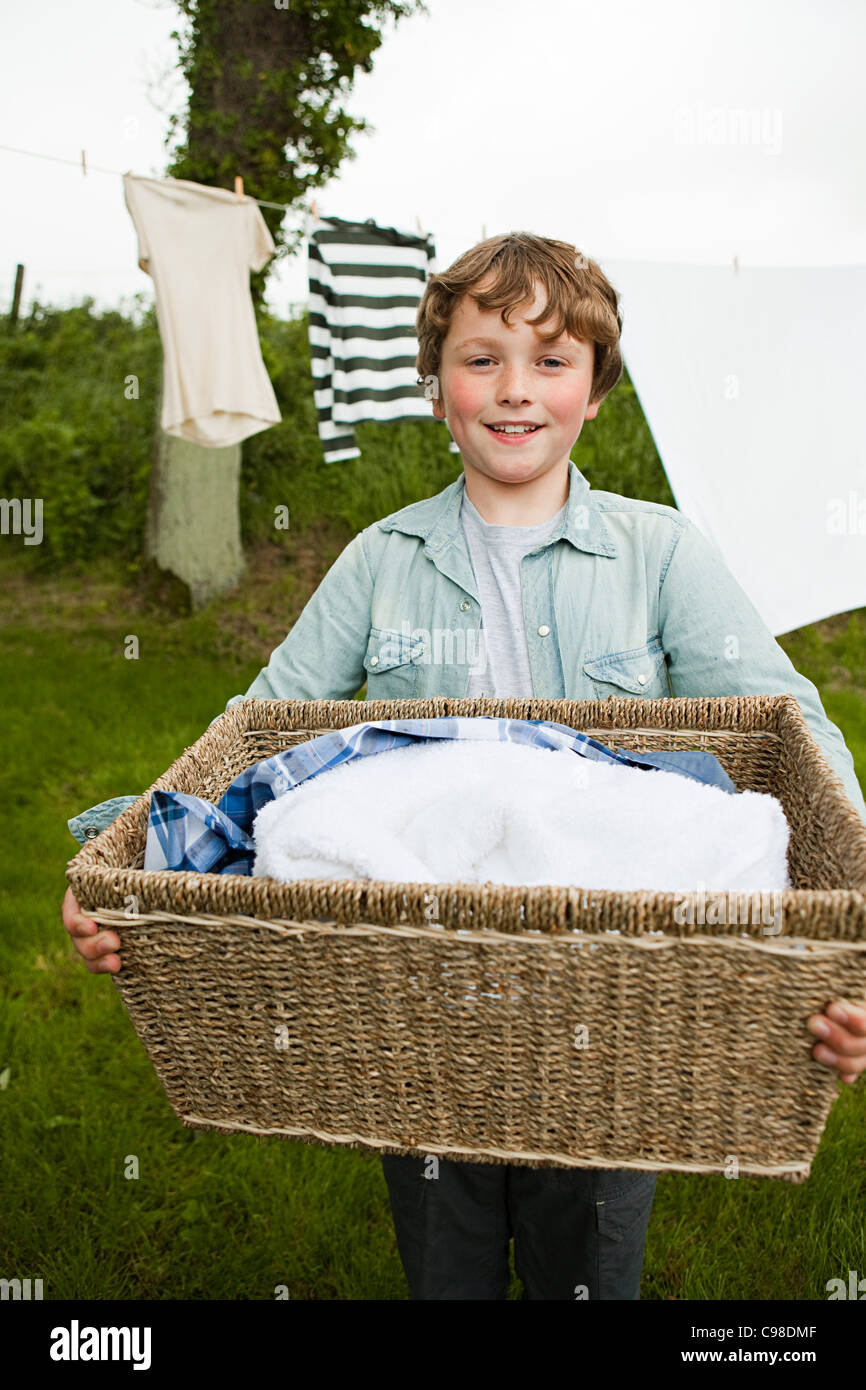 Boy carrying washing basket Stock Photo