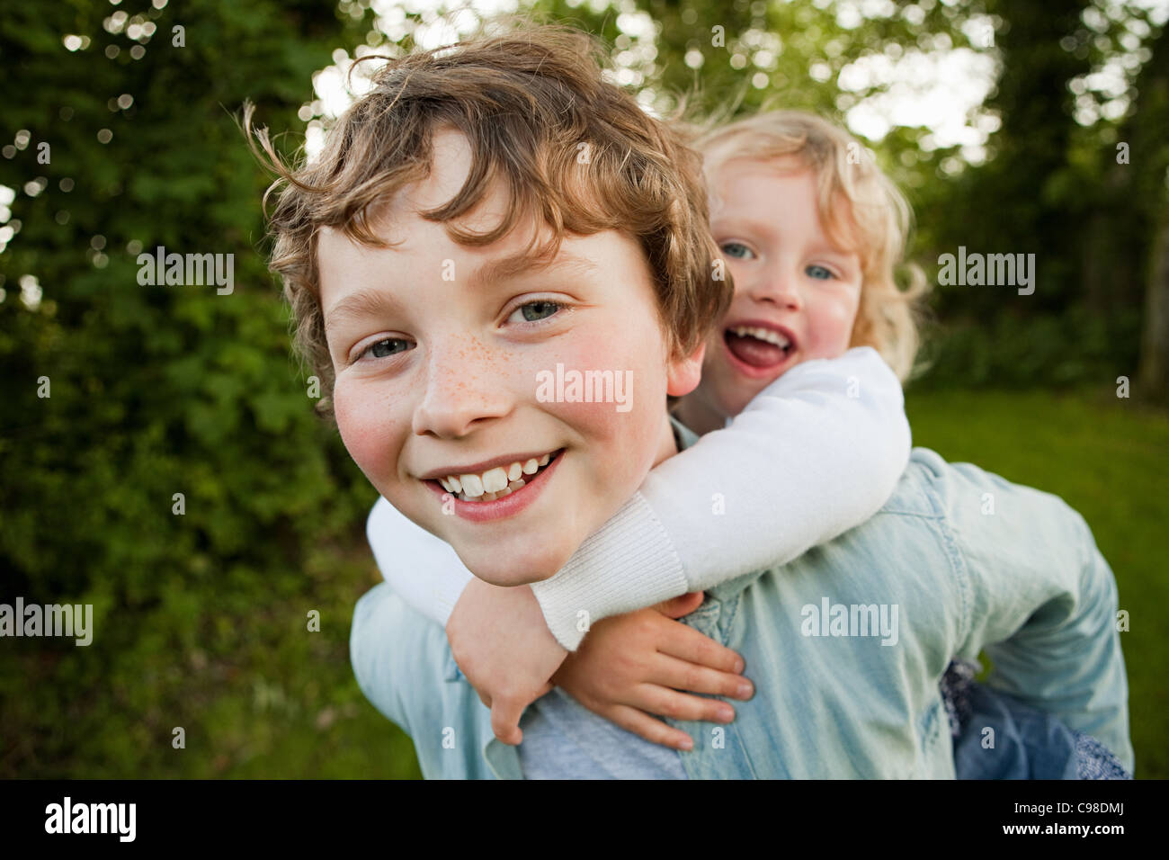 Brother giving sister piggyback Stock Photo
