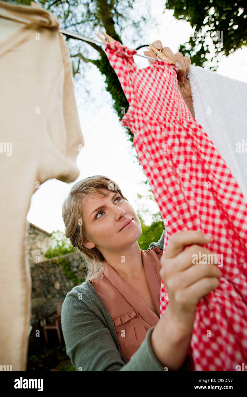 Woman hanging laundry on clothesline Stock Photo