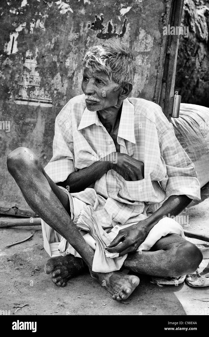 Old Indian man sitting on the street. Andhra Pradesh, India. Monochrome Stock Photo
