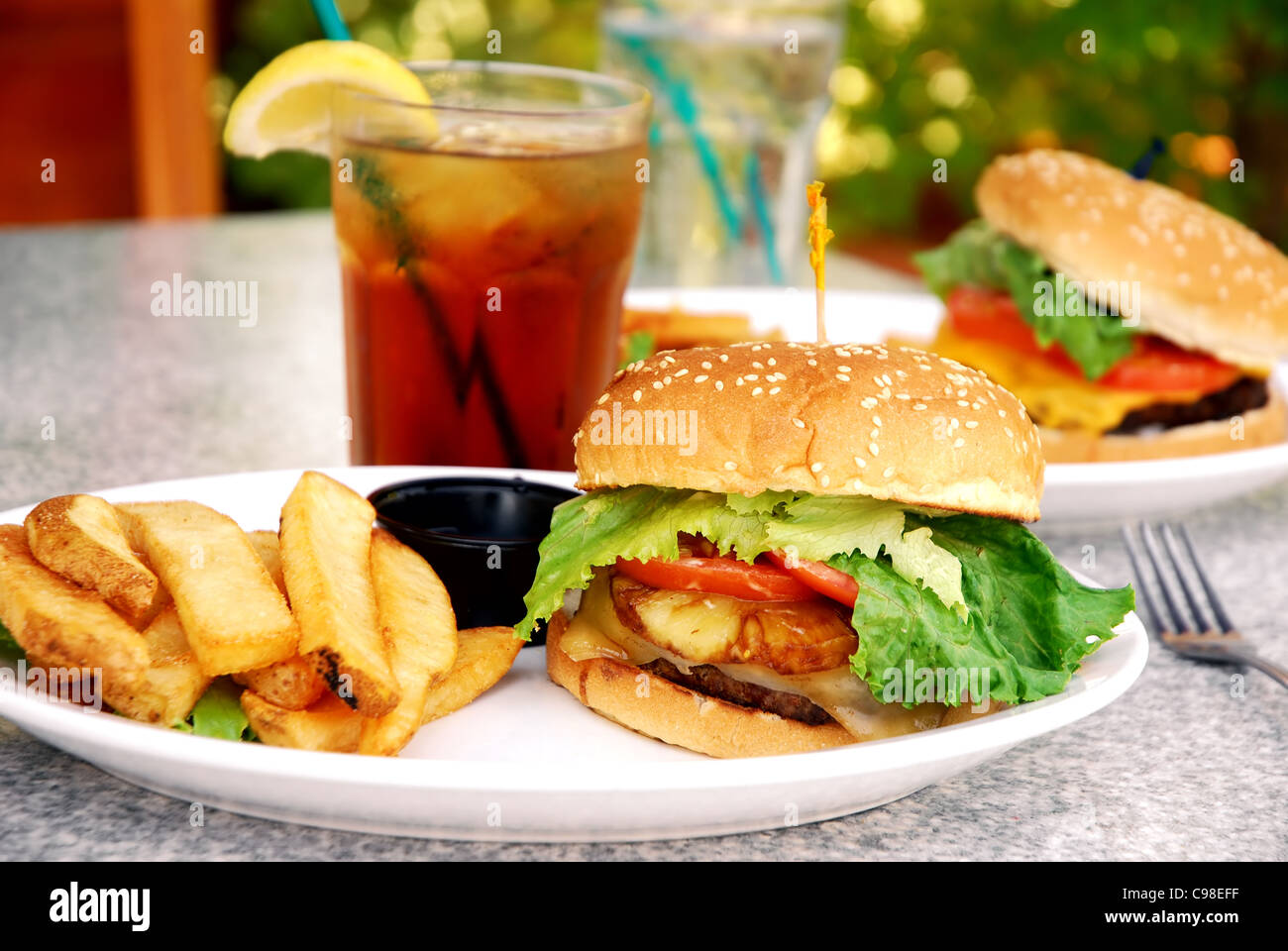 Teriyaki burger with large French fries at an outdoor restaurant Stock Photo