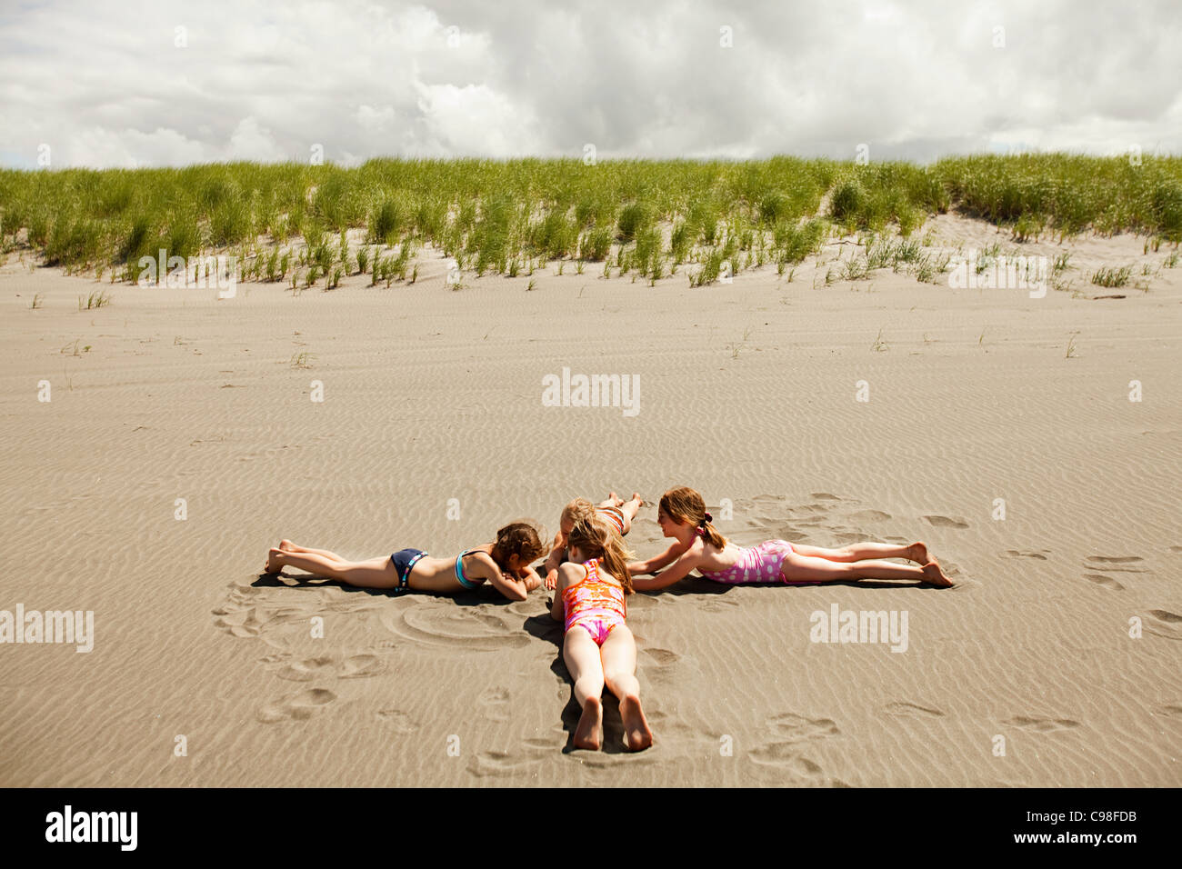 Girls lying on sand beach Stock Photo Alamy