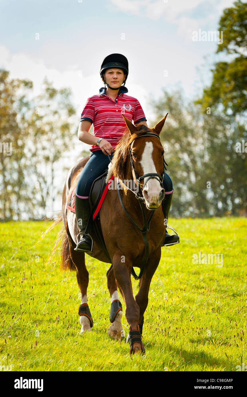 female riding horse towards camera.upright format.copy space Stock