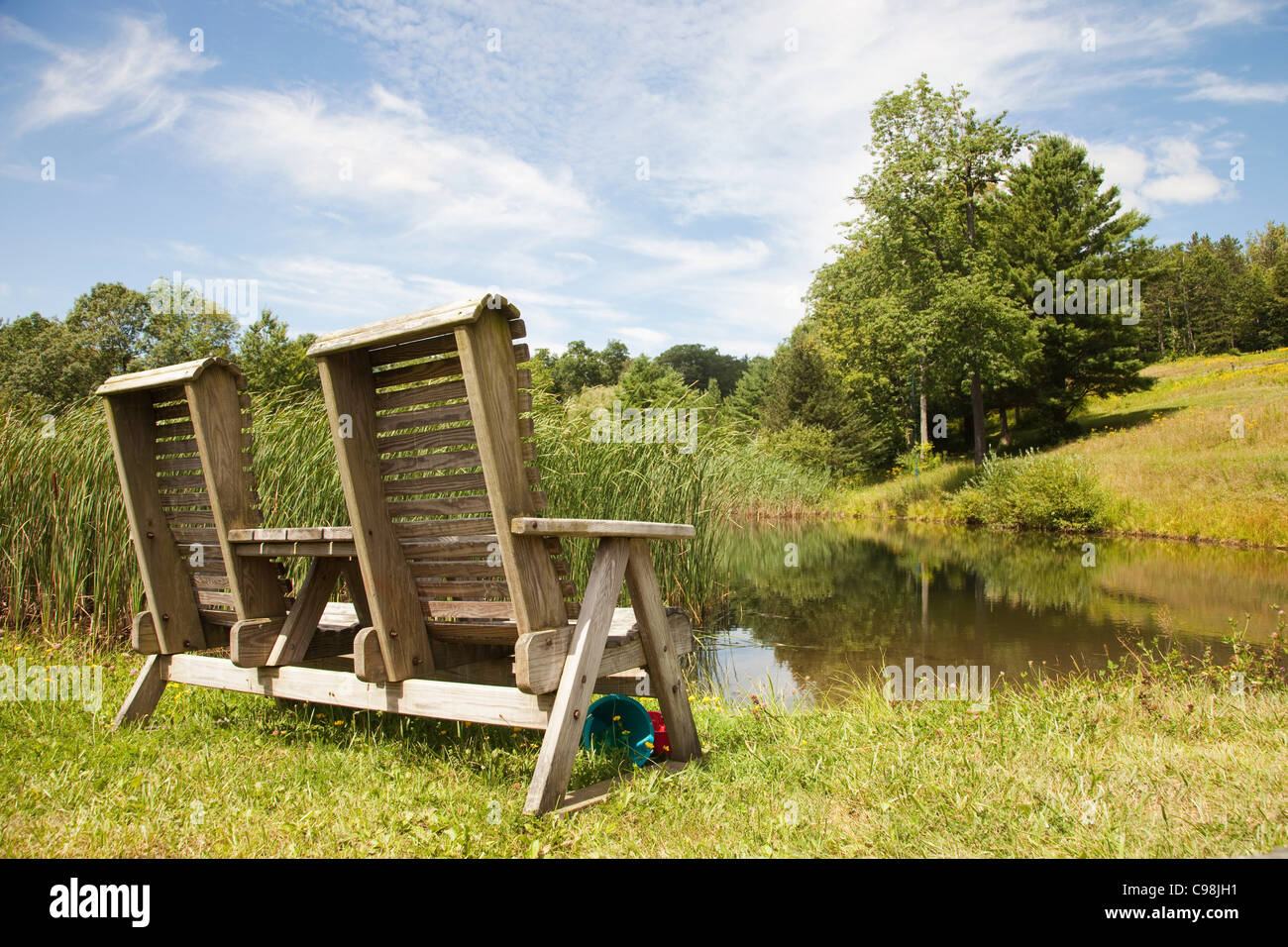 A double wooden chair positioned by lake Stock Photo - Alamy
