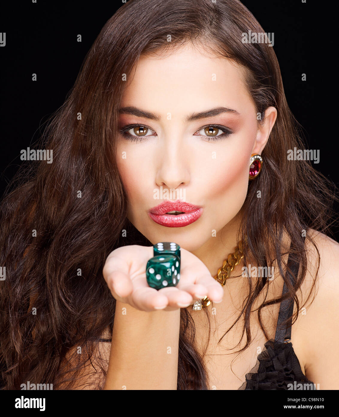 pretty young woman holding dices on black background Stock Photo