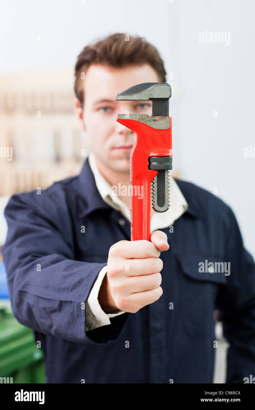 Apprentice plumber holding up adjustable hires stock photography and