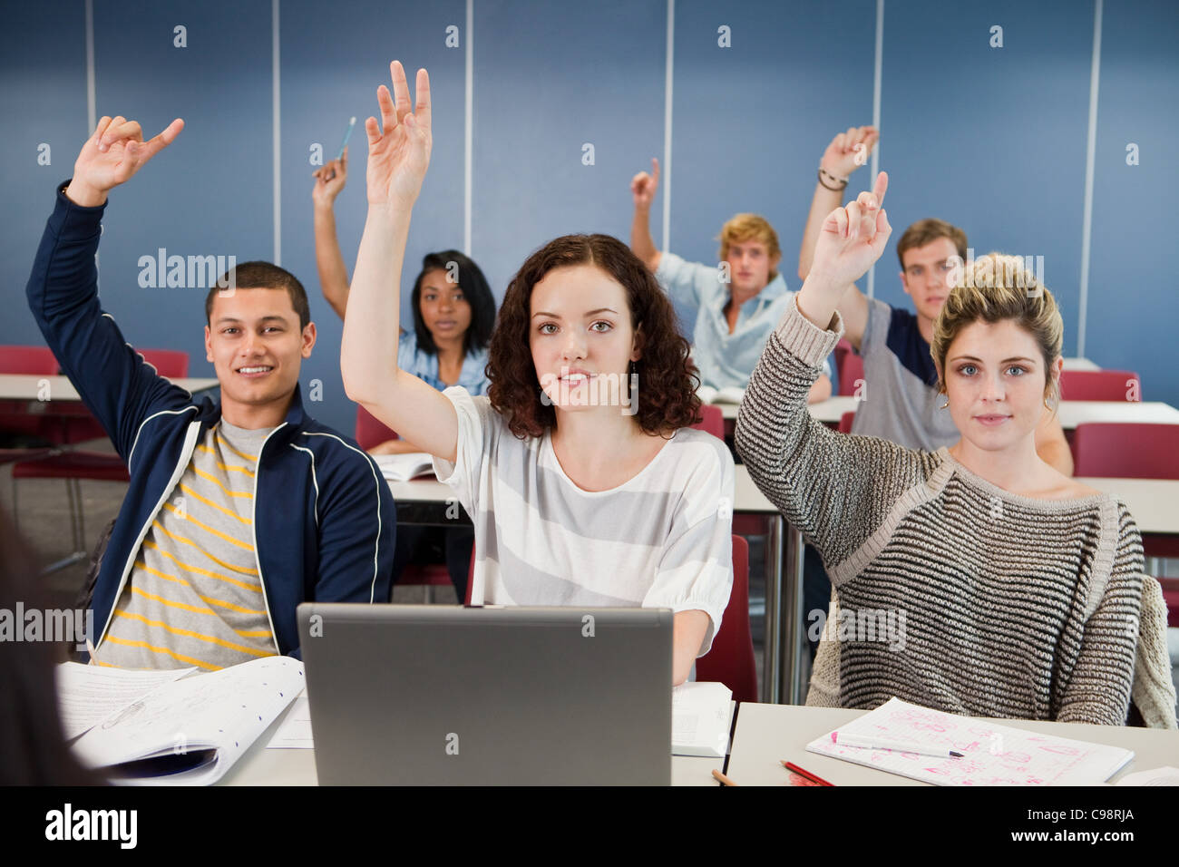 University students holding up hands class Stock Photo