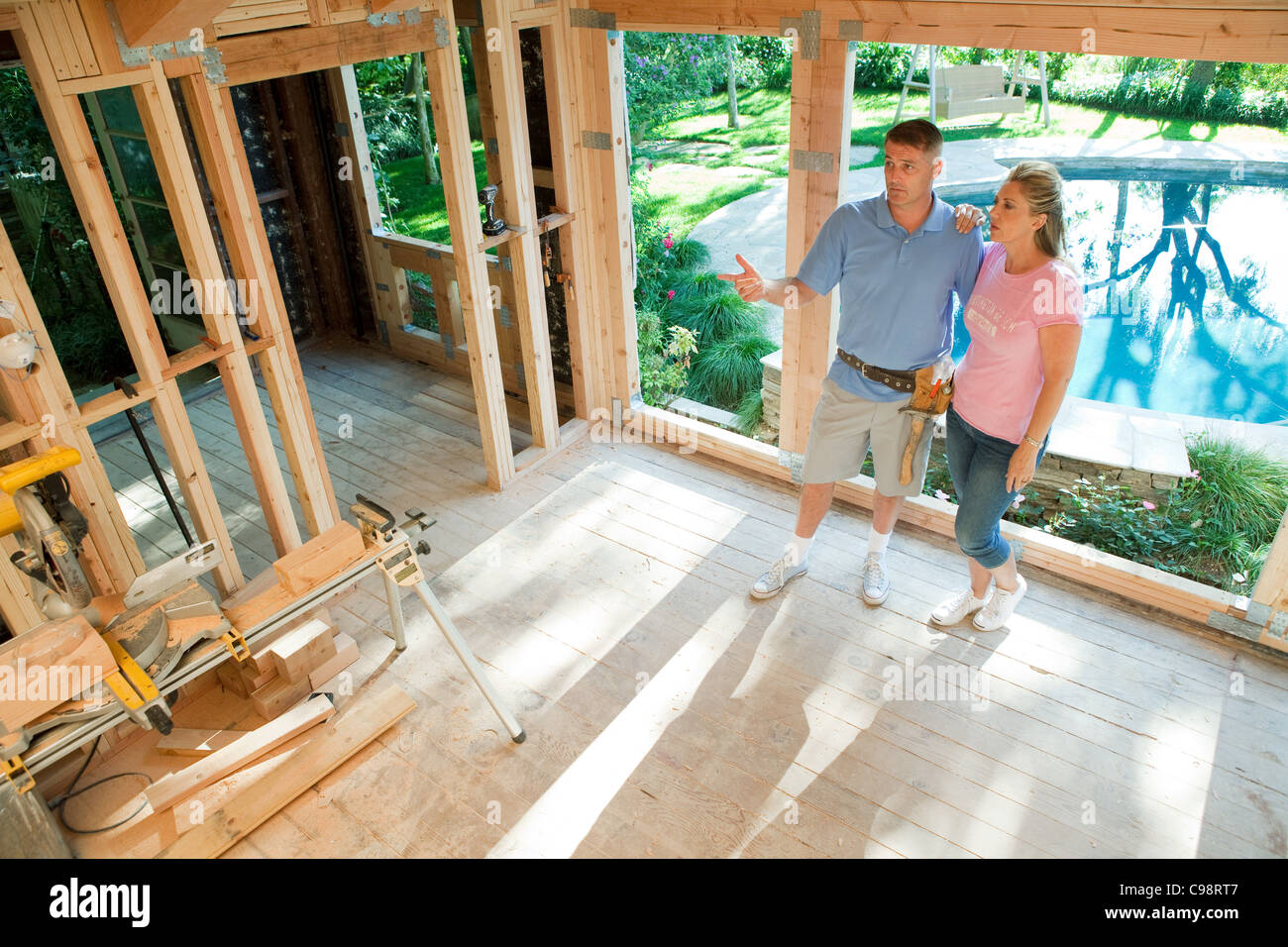 Mature couple standing construction frame home extension Stock Photo