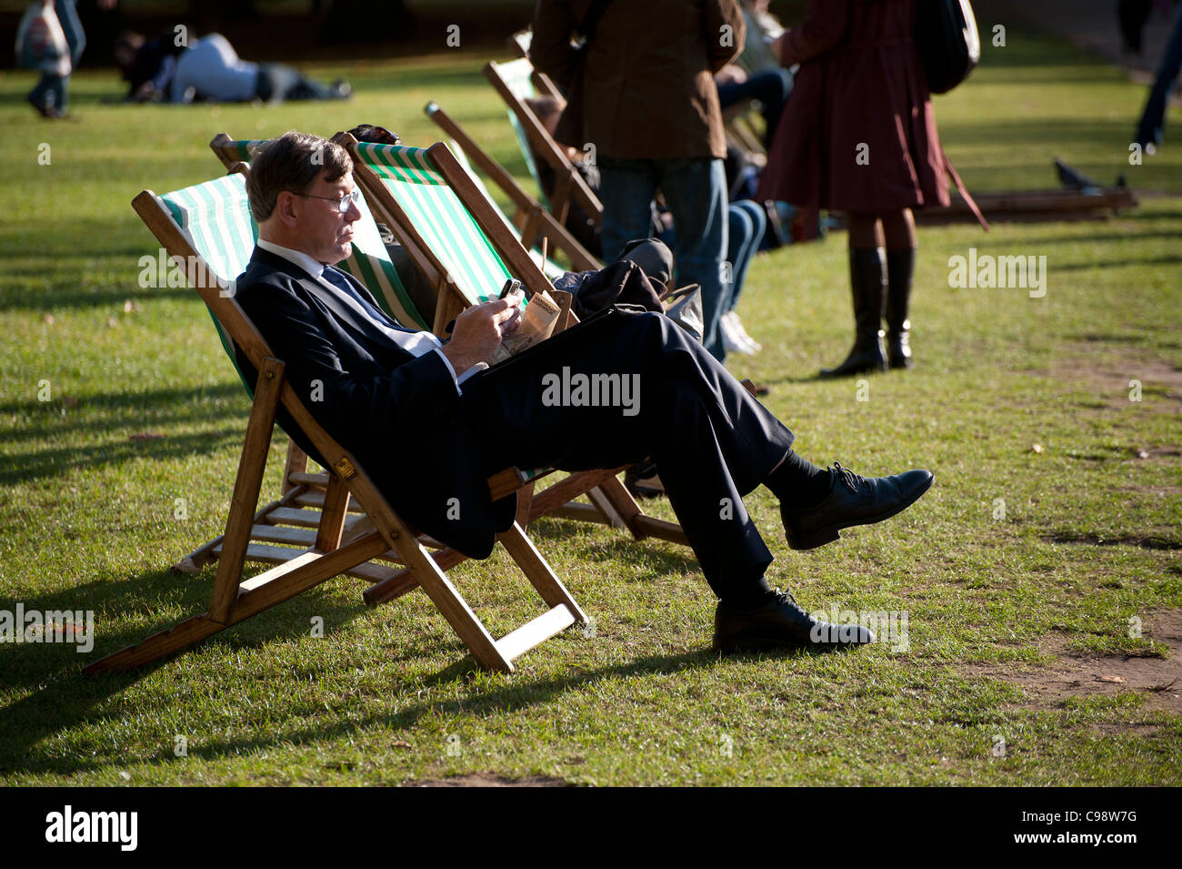 sitting in a deck chair in Londons Green park Stock Photo