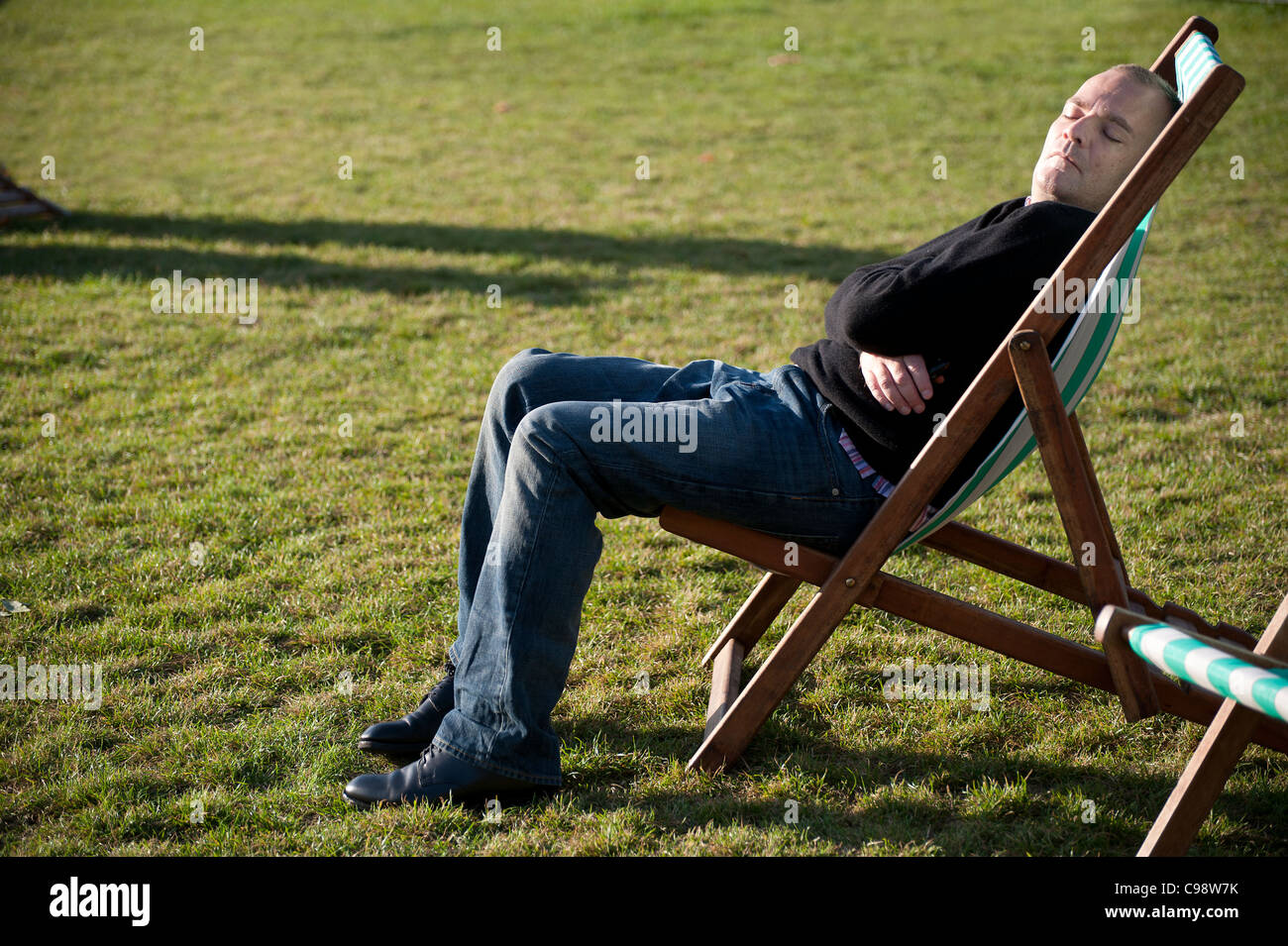 sitting in a deck chair in Londons Green park Stock Photo - Alamy