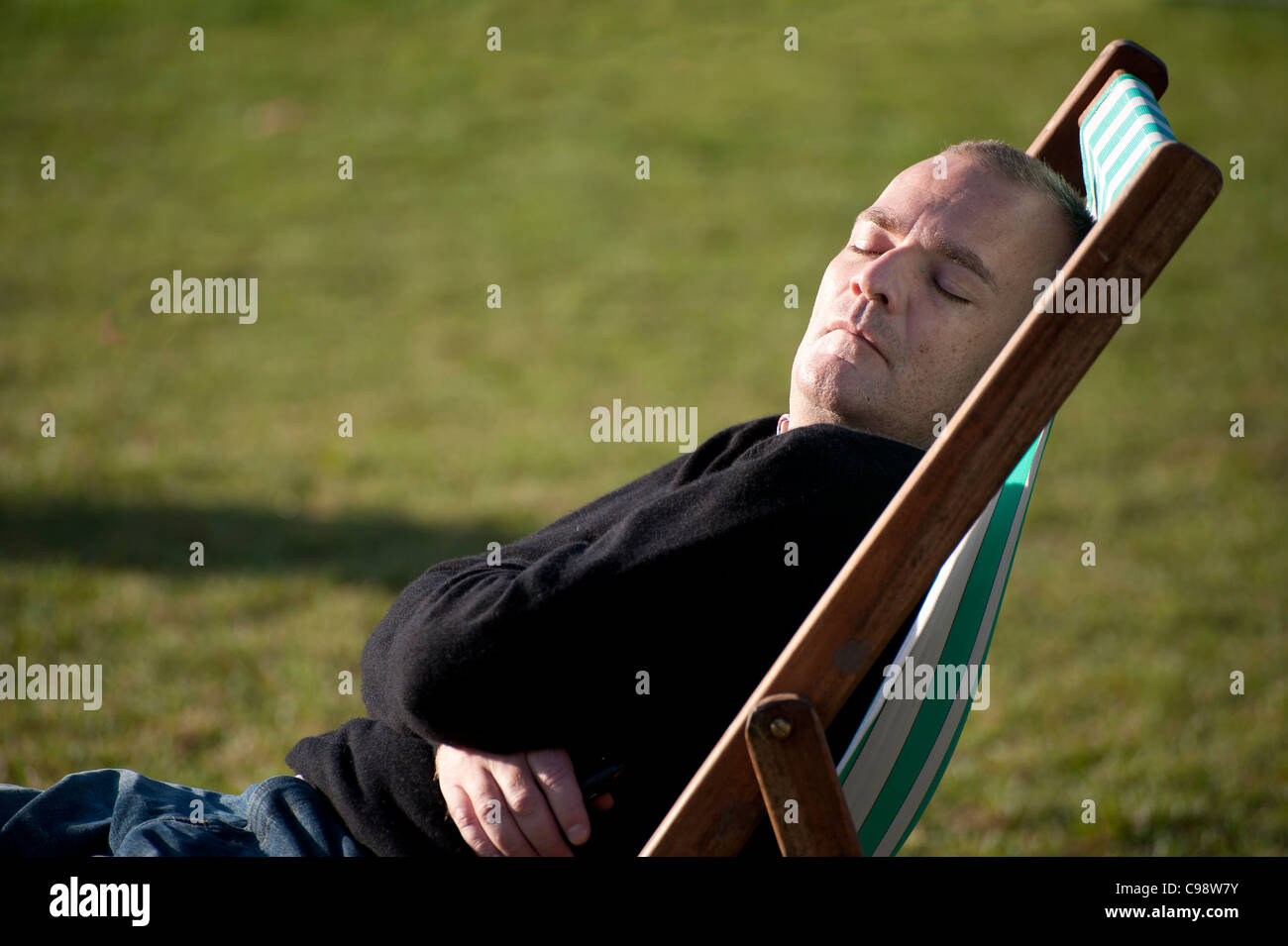sitting in a deck chair in Londons Green park Stock Photo - Alamy