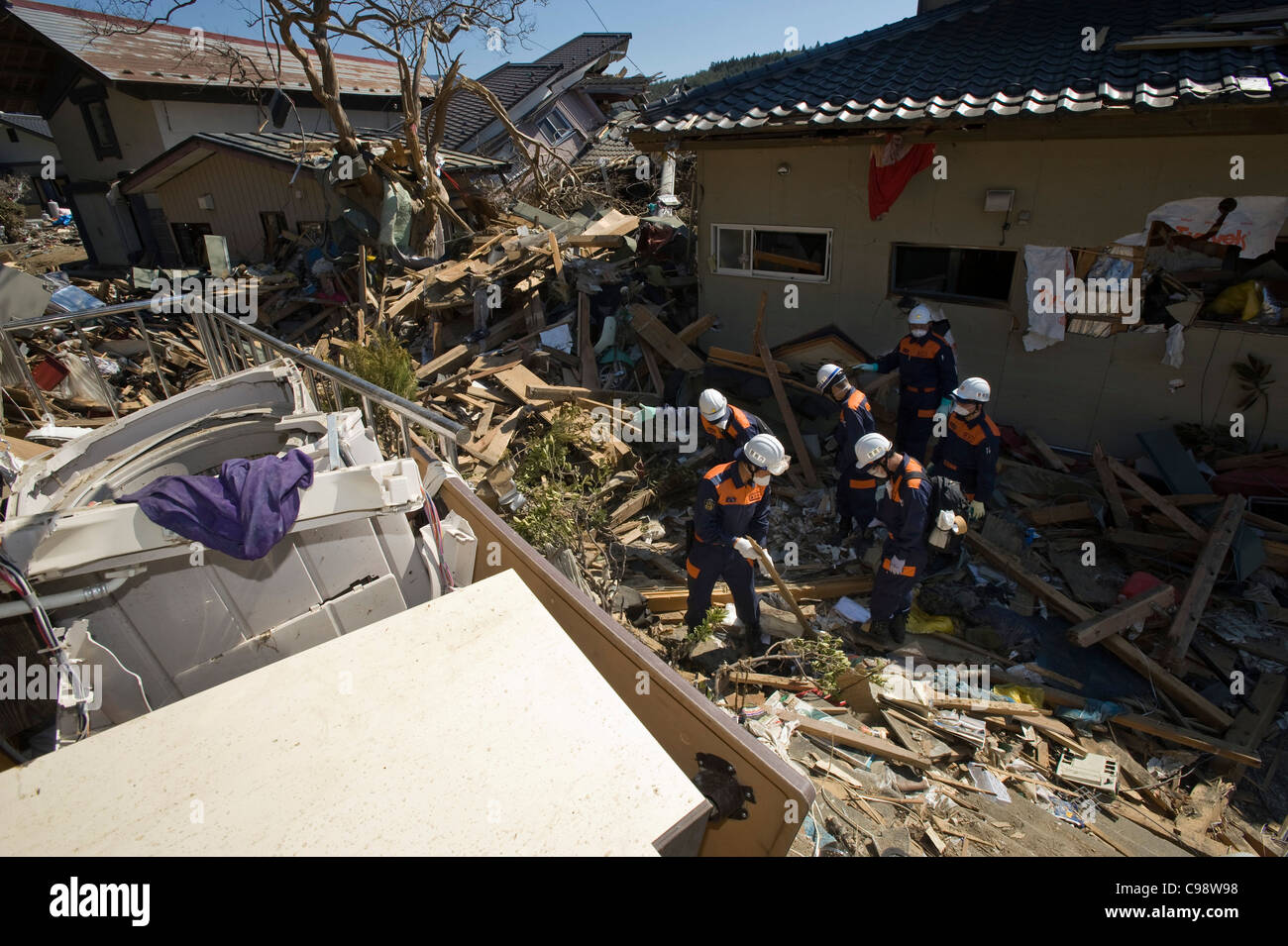 Police officers search through the rubble for bodies of residents swept away by the March 11 tsunami in Rikuzentakata, Japan Stock Photo