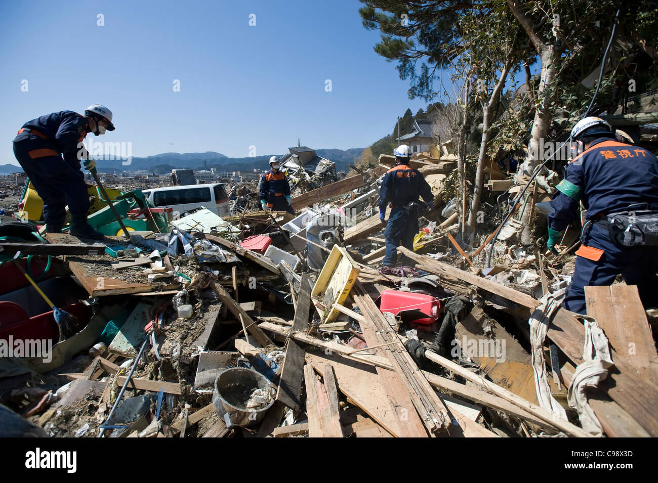 Police officers search through the rubble for bodies of residents swept away by the March 11 tsunami in Rikuzentakata, Japan Stock Photo