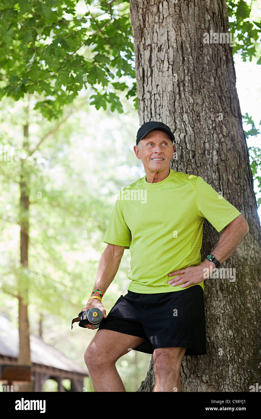 Senior man leaning against tree hi-res stock photography and images - Alamy