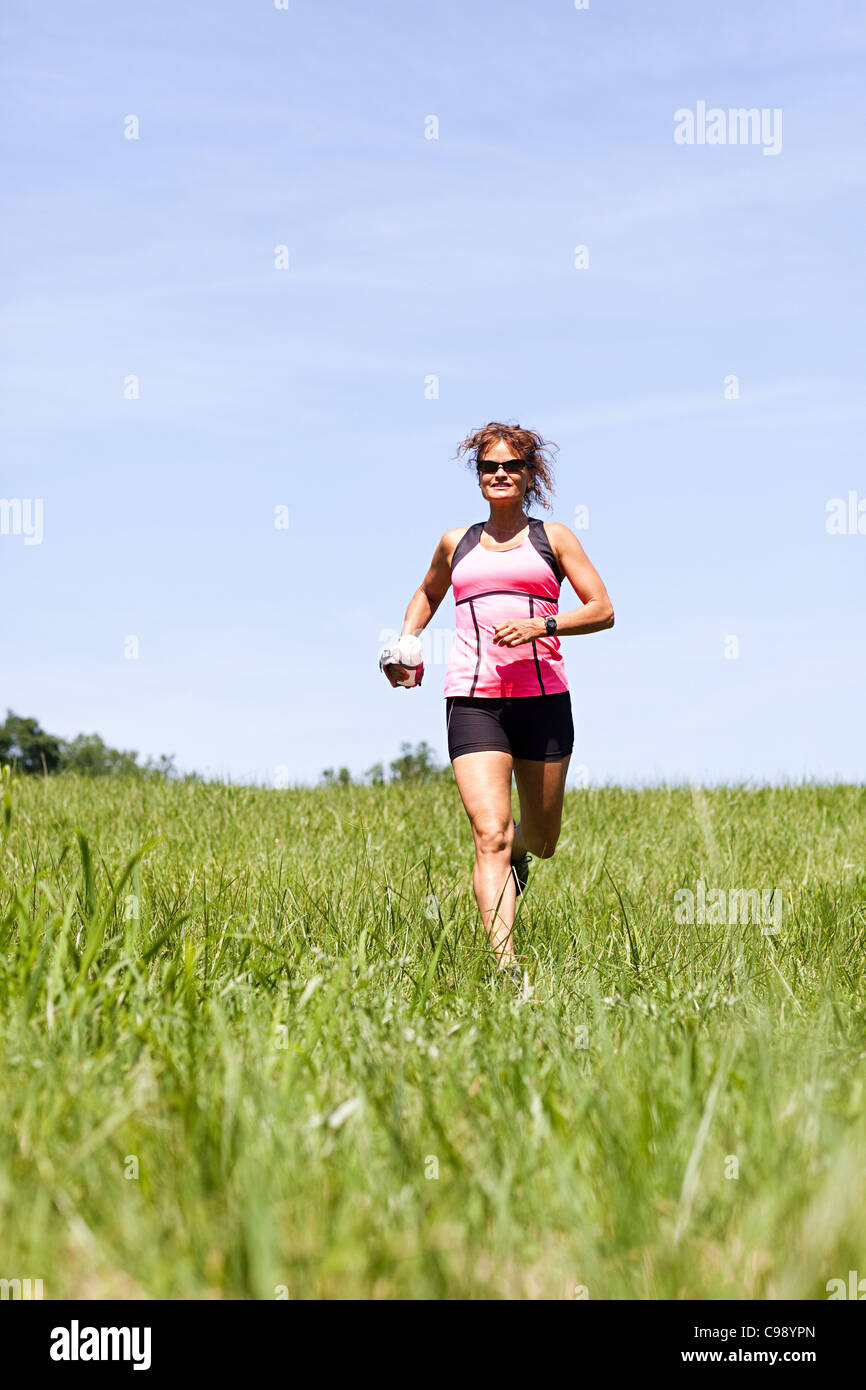 Woman running through field Stock Photo Alamy