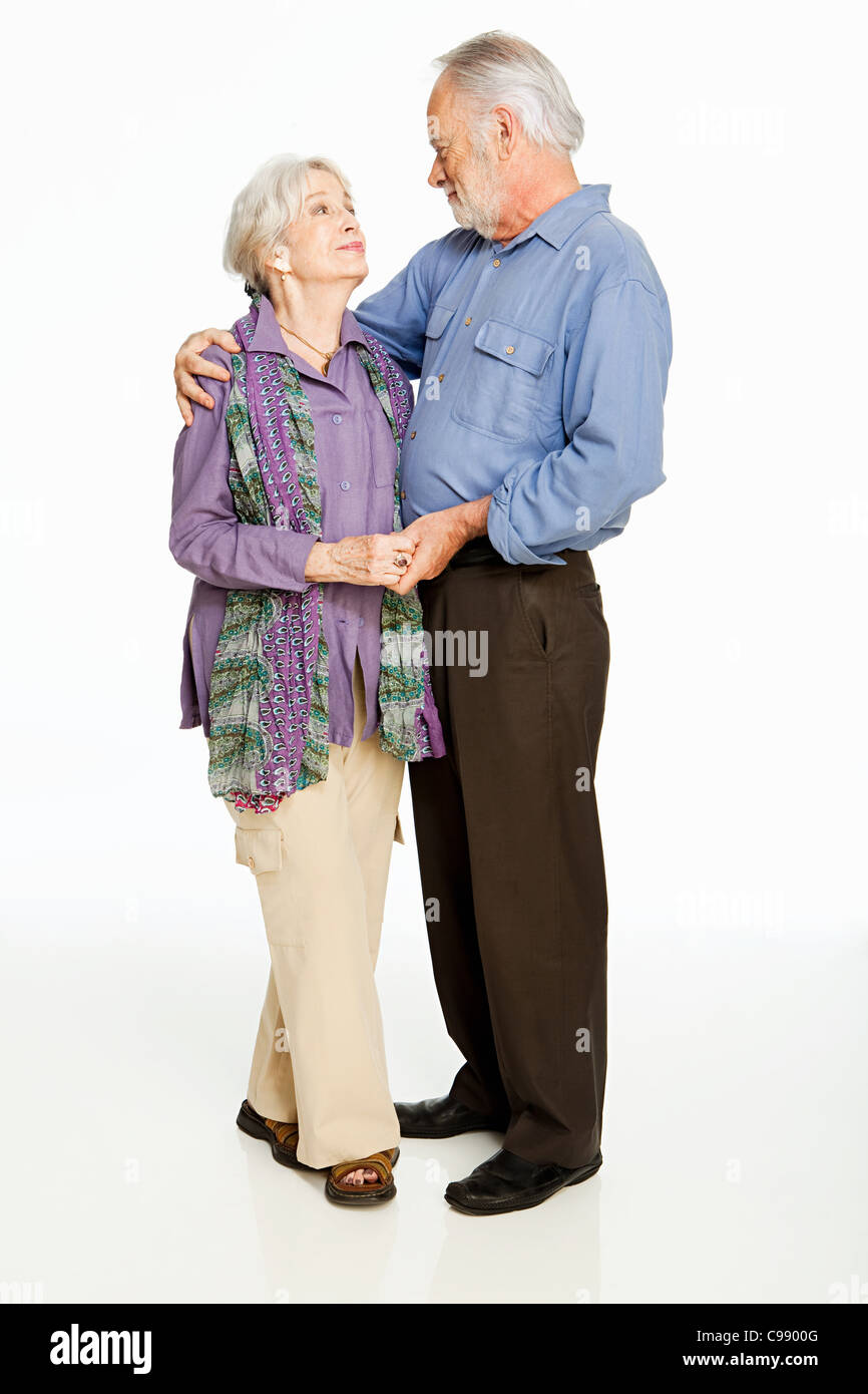 Senior couple embracing against white background Stock Photo