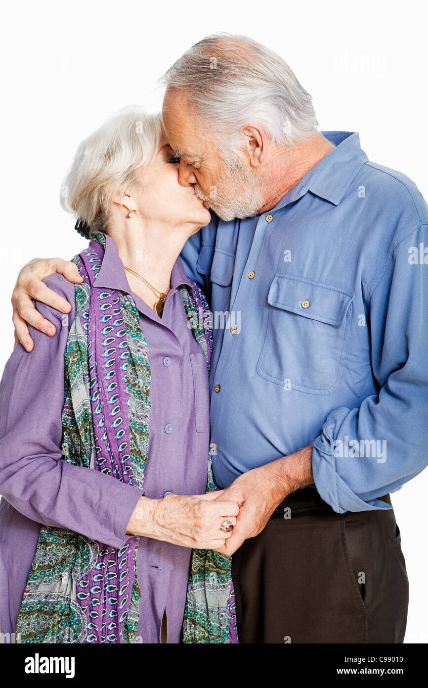 Senior couple kissing against white background Stock Photo