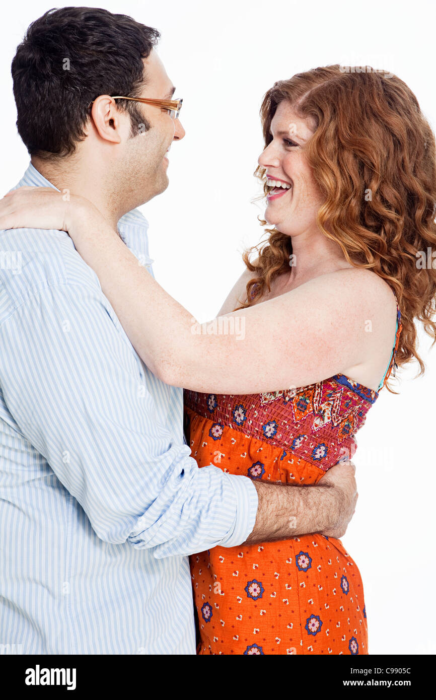 Couple embracing against white background Stock Photo
