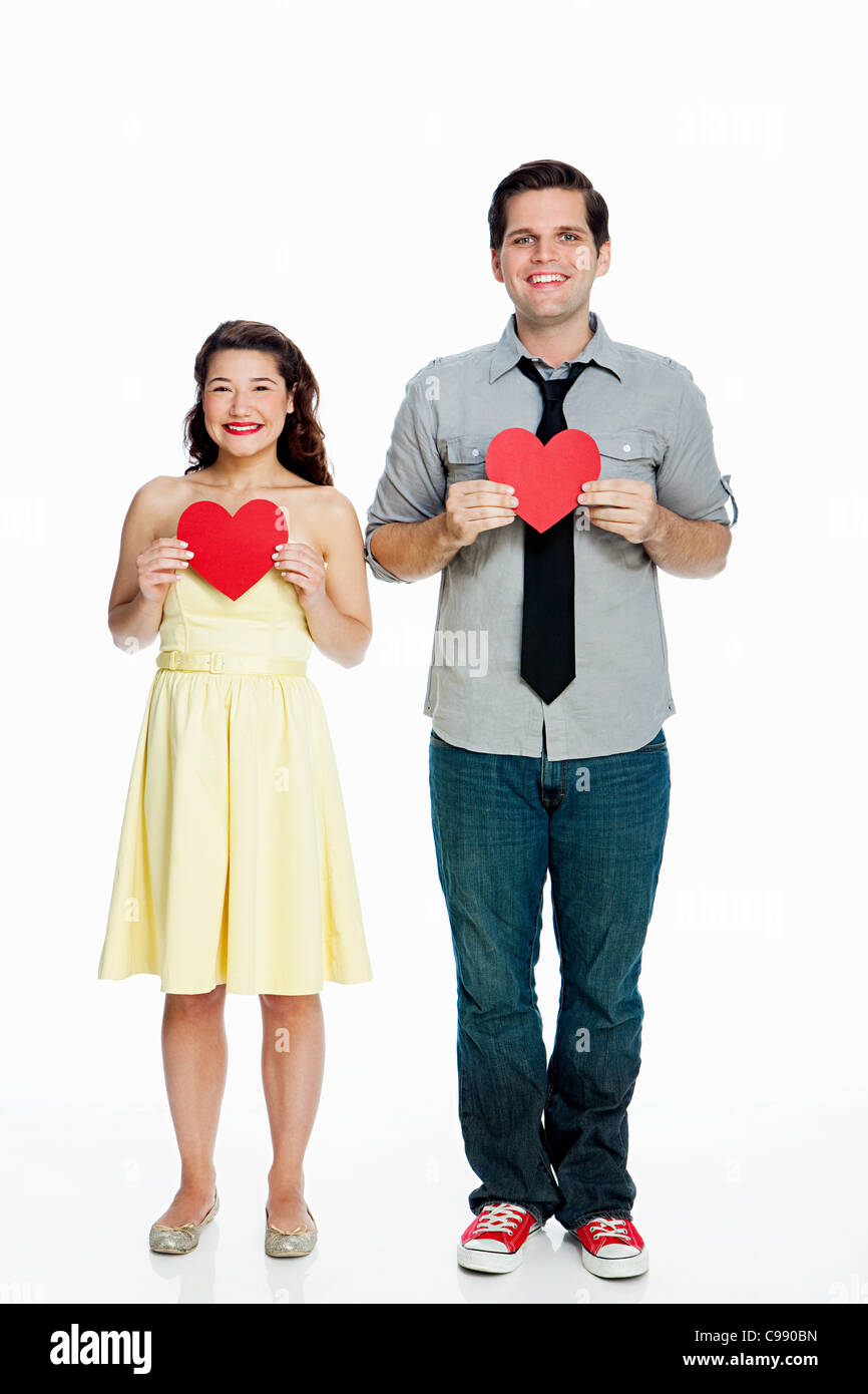 Young couple holding heart shapes against white background Stock Photo ...