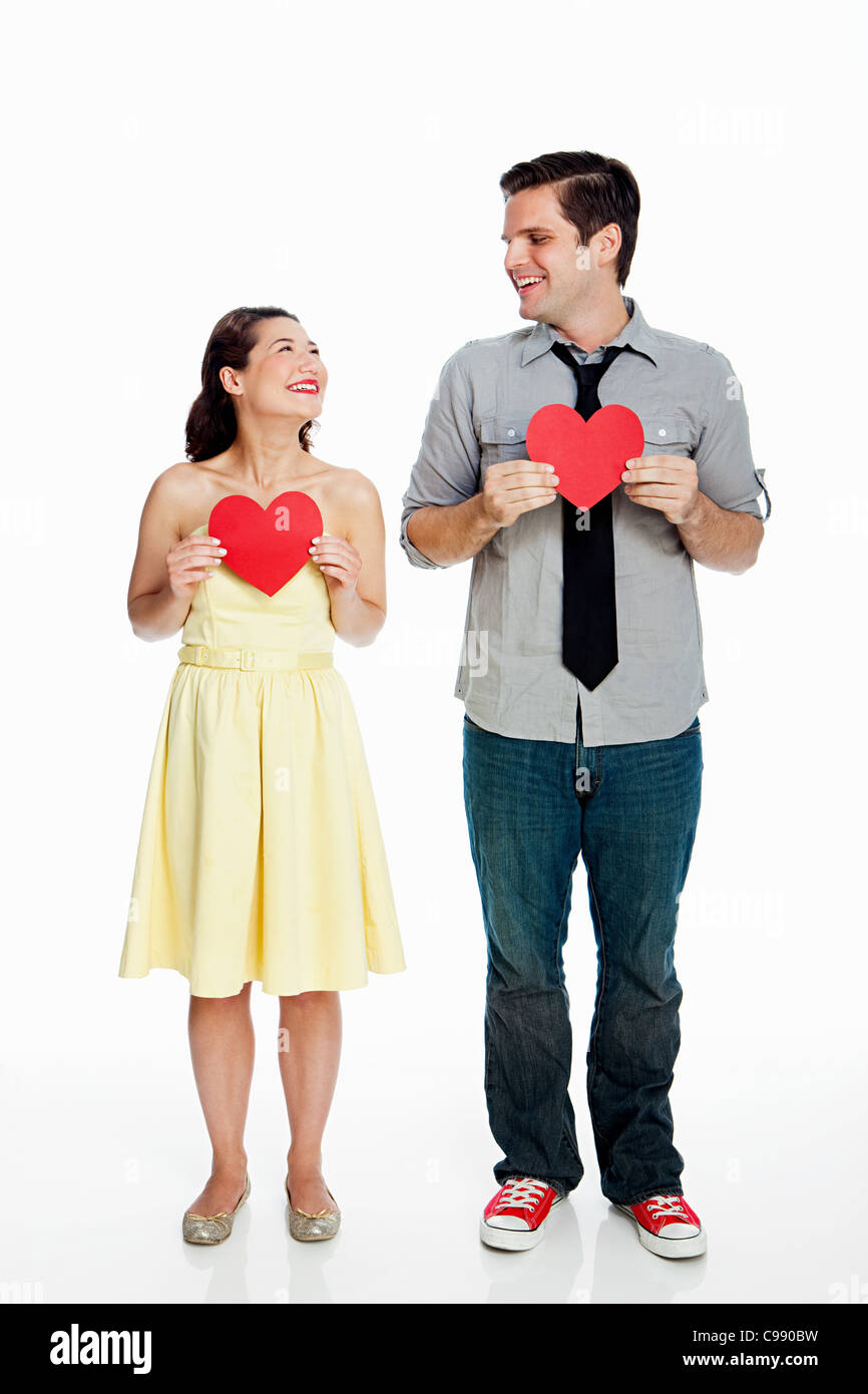 Young couple holding heart shapes against white background Stock Photo ...