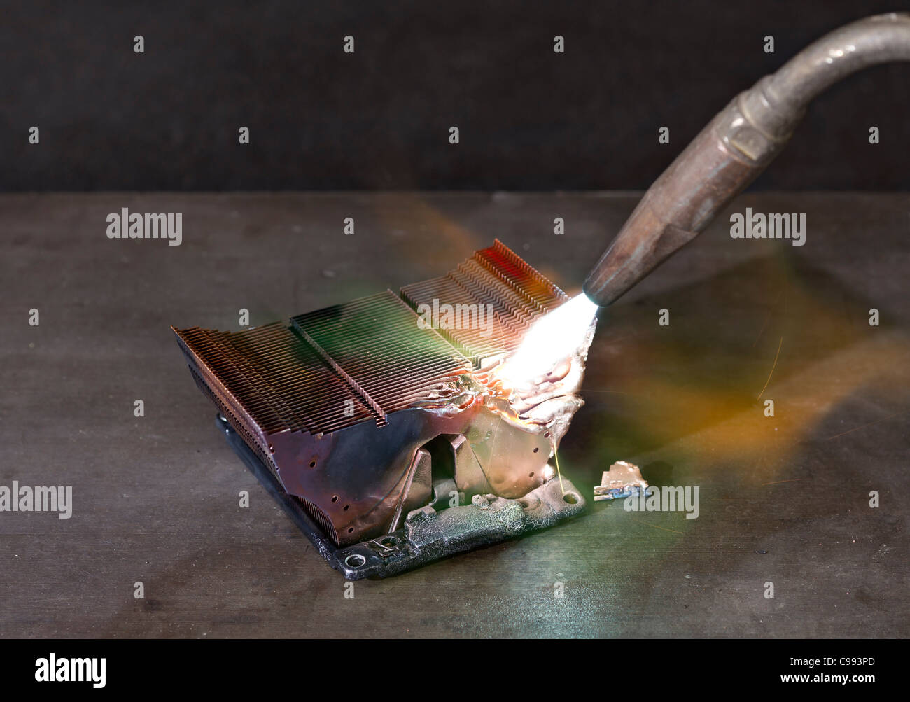 melting heat sink and welding torch on metallic ground Stock Photo