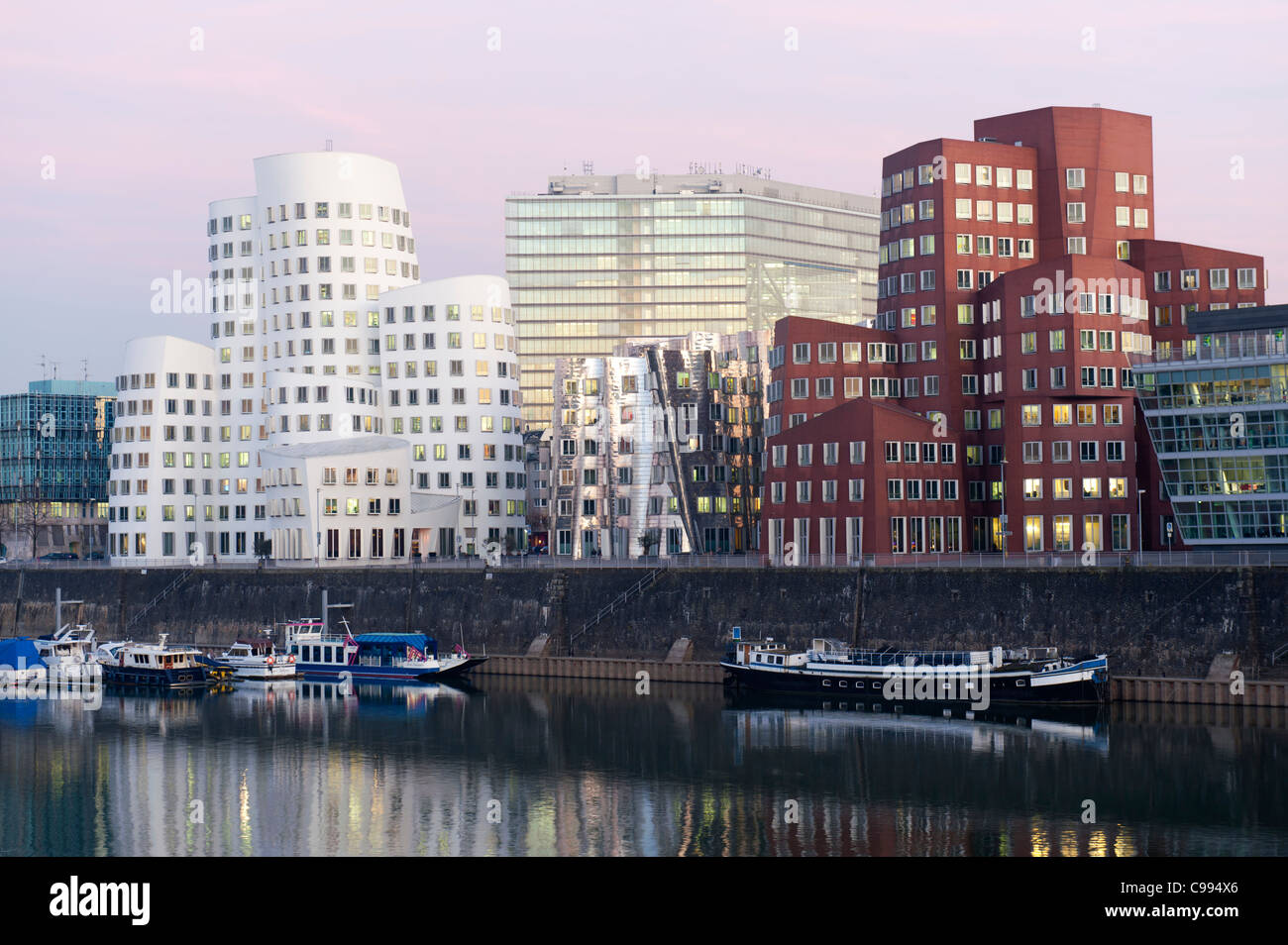 Neuer Zollhof office buildings at night in modern property development at Media Harbour or Medienhafen in Dusseldorf Germany Stock Photo