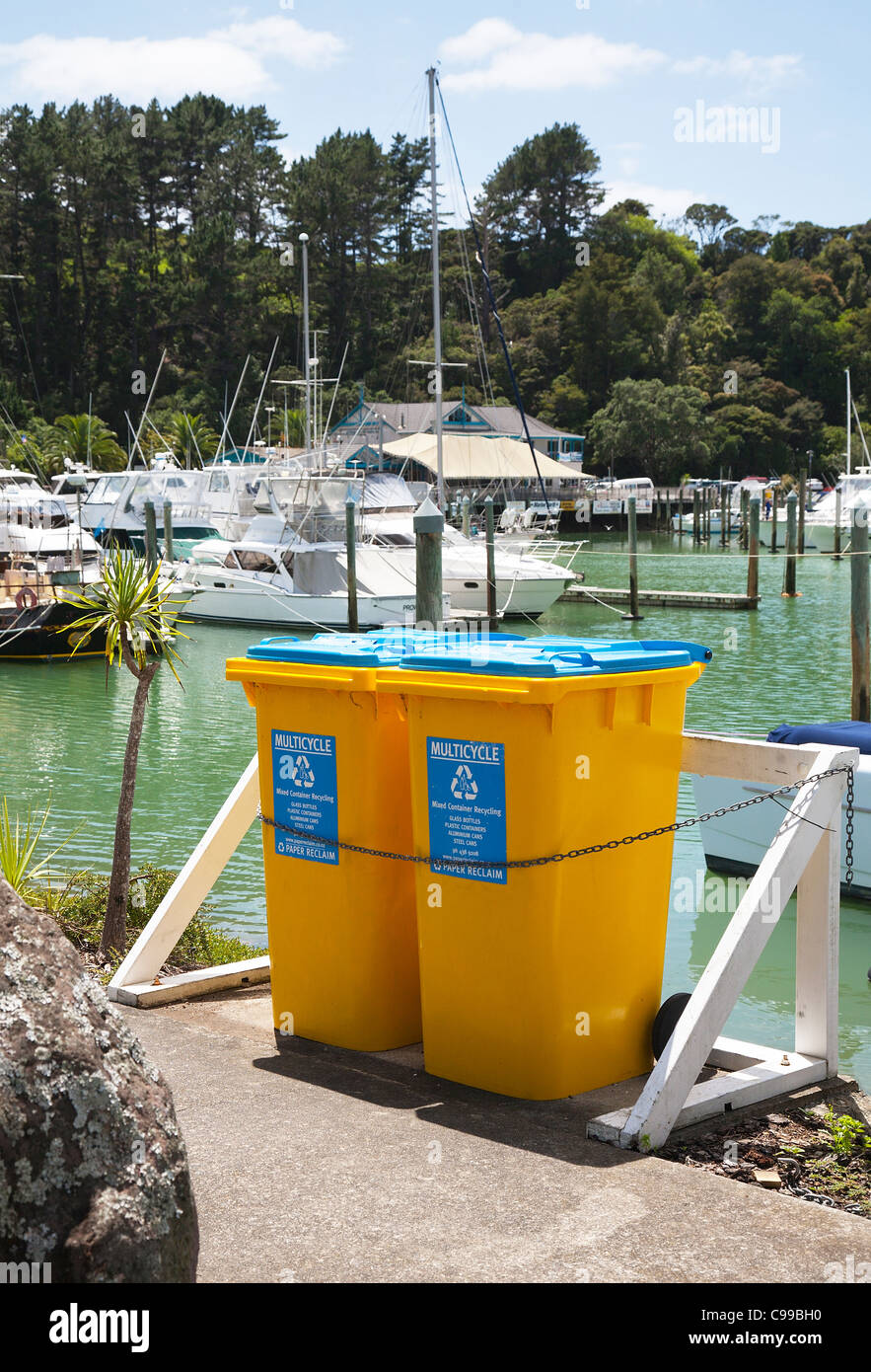 Yellow recycling rubbish wheelie bins. The marina at Tutukaka