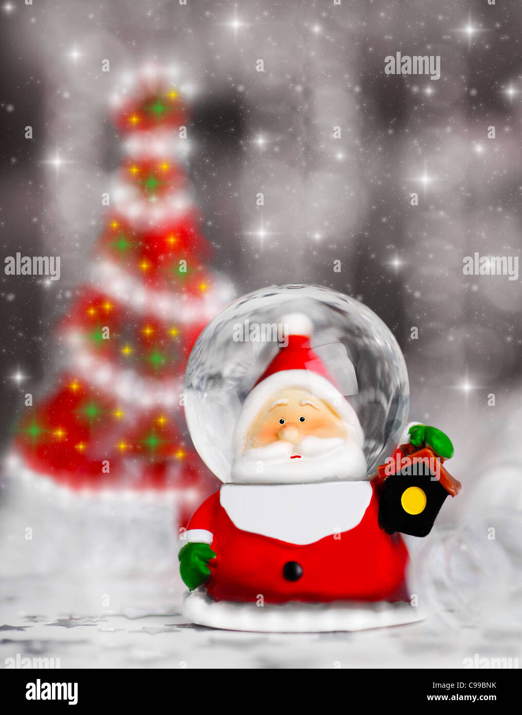 Snow globe Santa Claus, Christmas tree decoration, traditional winter holiday ornament with shiny blur lights background, select Stock Photo