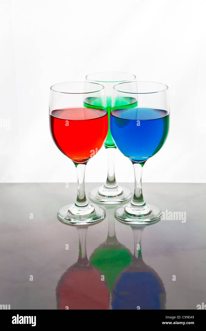 three wine glasses with red, blue, and green liquid for the RGB colors Stock Photo