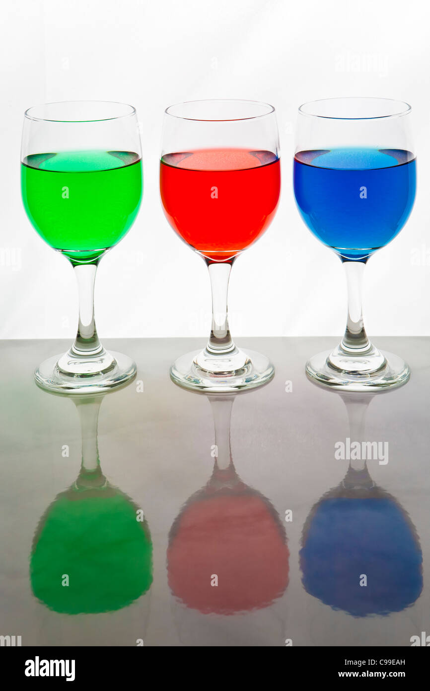 three wine glasses with red, blue, and green liquid for the RGB colors Stock Photo