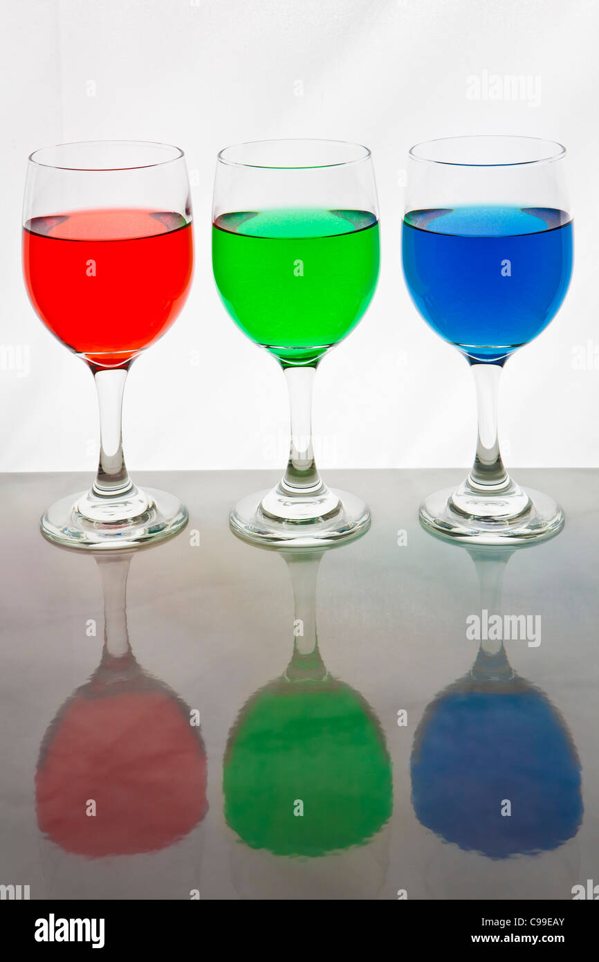 three wine glasses with red, blue, and green liquid for the RGB colors Stock Photo