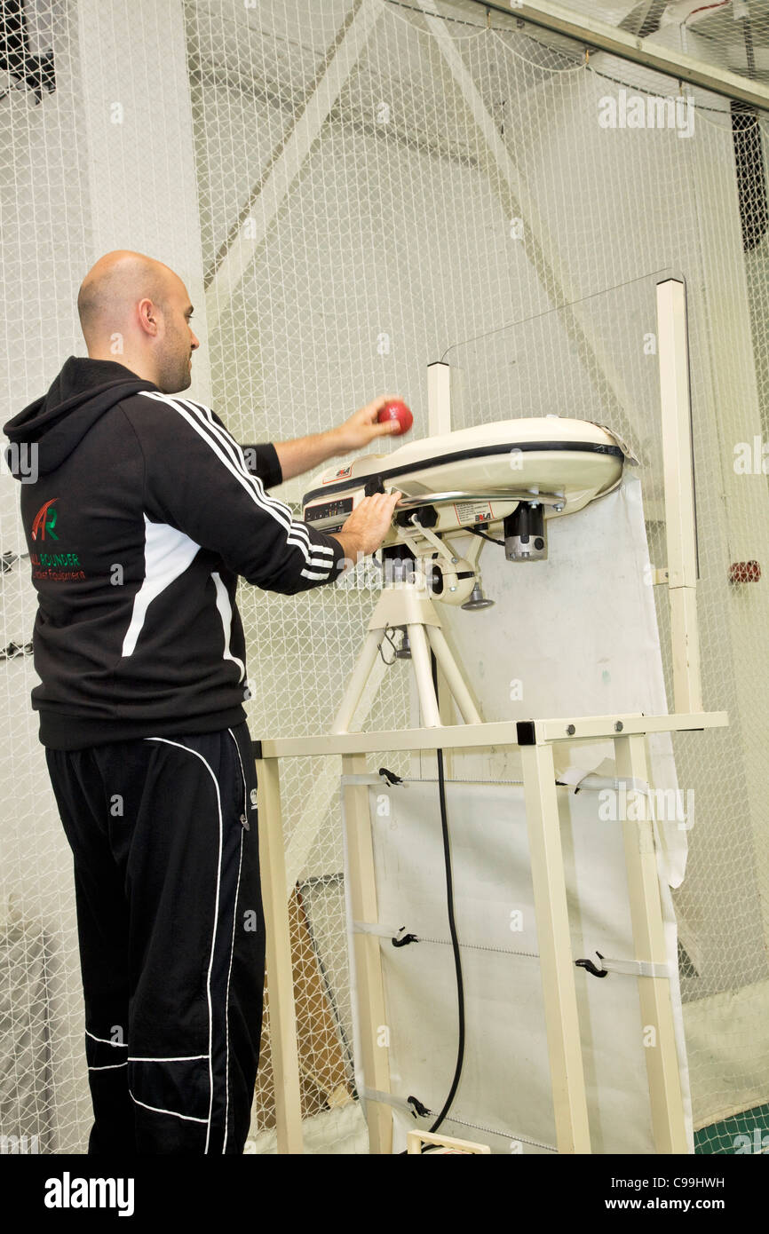Players operating a bowling machine at Headingley, indoor nets Stock